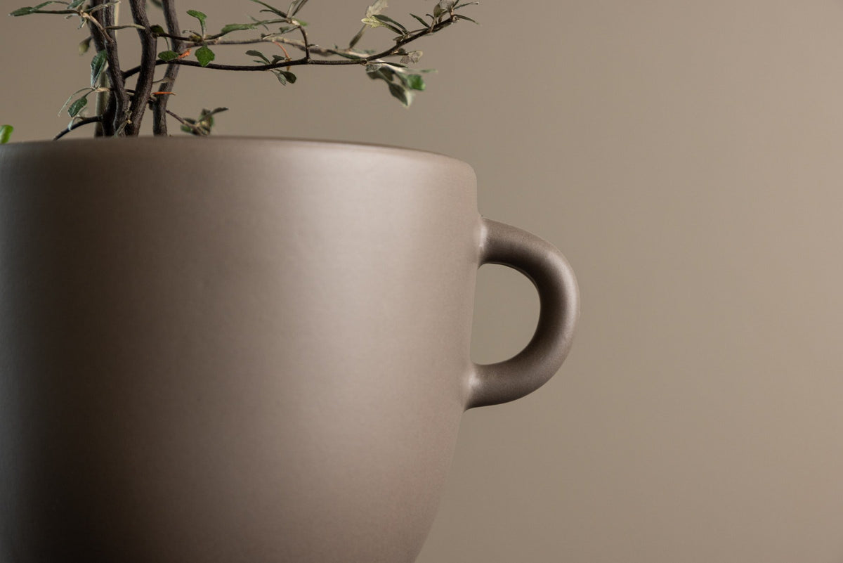 Beige Cent Vase von Venture Home aus Steinzeug mit wellenförmiger Struktur und zwei asymmetrisch angebrachten Griffen an den Seiten.