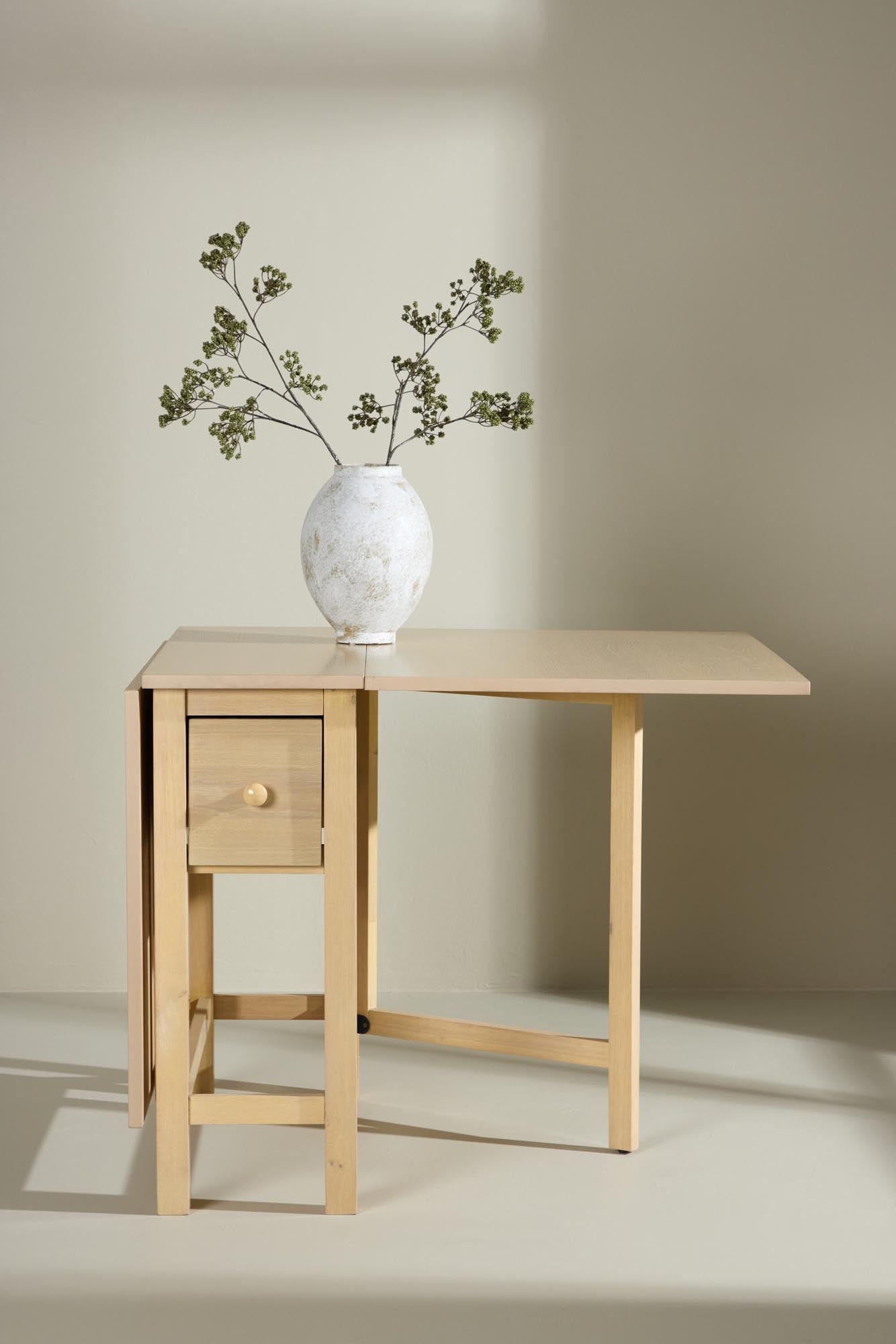 Eleganter, erweiterbarer Esstisch aus robustem MDF mit weissgewaschenem Finish, ideal für stilvolle Mahlzeiten.