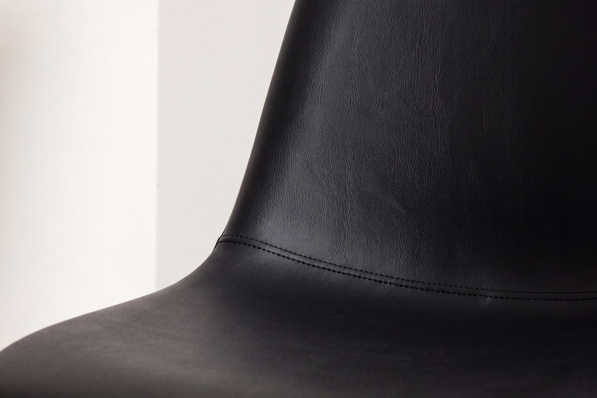 Polar Stuhl von Venture Home mit schwarzem Polyester-Samt-Bezug und schlanken schwarzen Stahlbeinen, runde Silhouette, freigestellt.