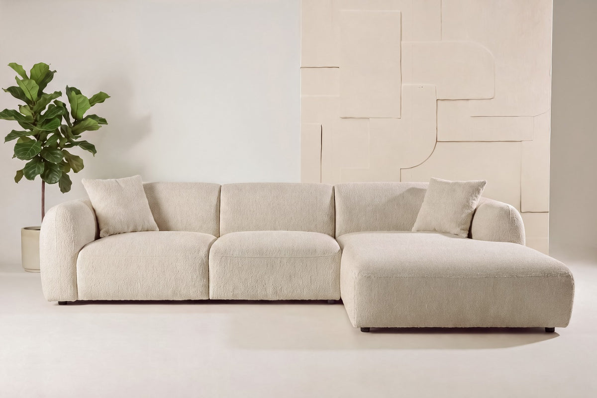 Beiges Chaiselongue-Sofa mit L-Form, Polyester-Bezug, schwarzen Holzbeinen und rechtsseitiger Chaiselongue, freigestellt fotografiert.