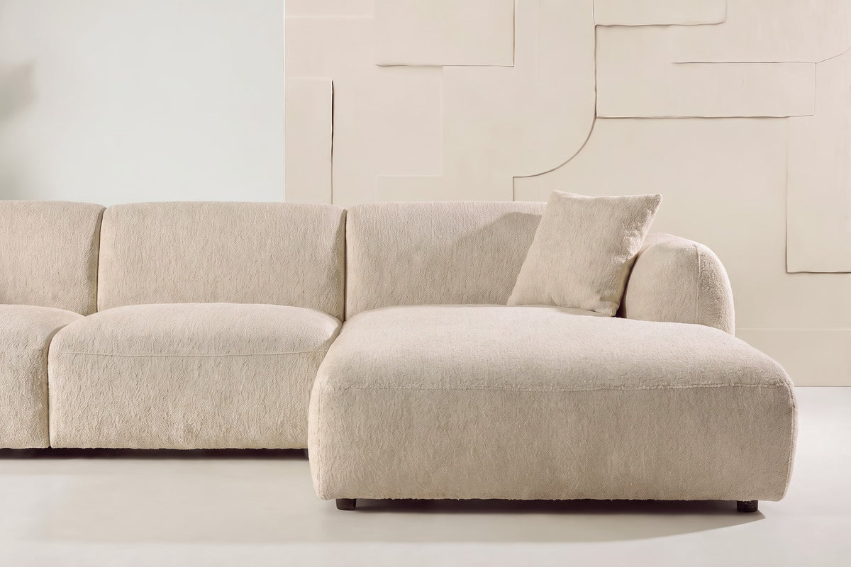 Beiges Chaiselongue-Sofa mit L-Form, Polyester-Bezug, schwarzen Holzbeinen und rechtsseitiger Chaiselongue, freigestellt fotografiert.