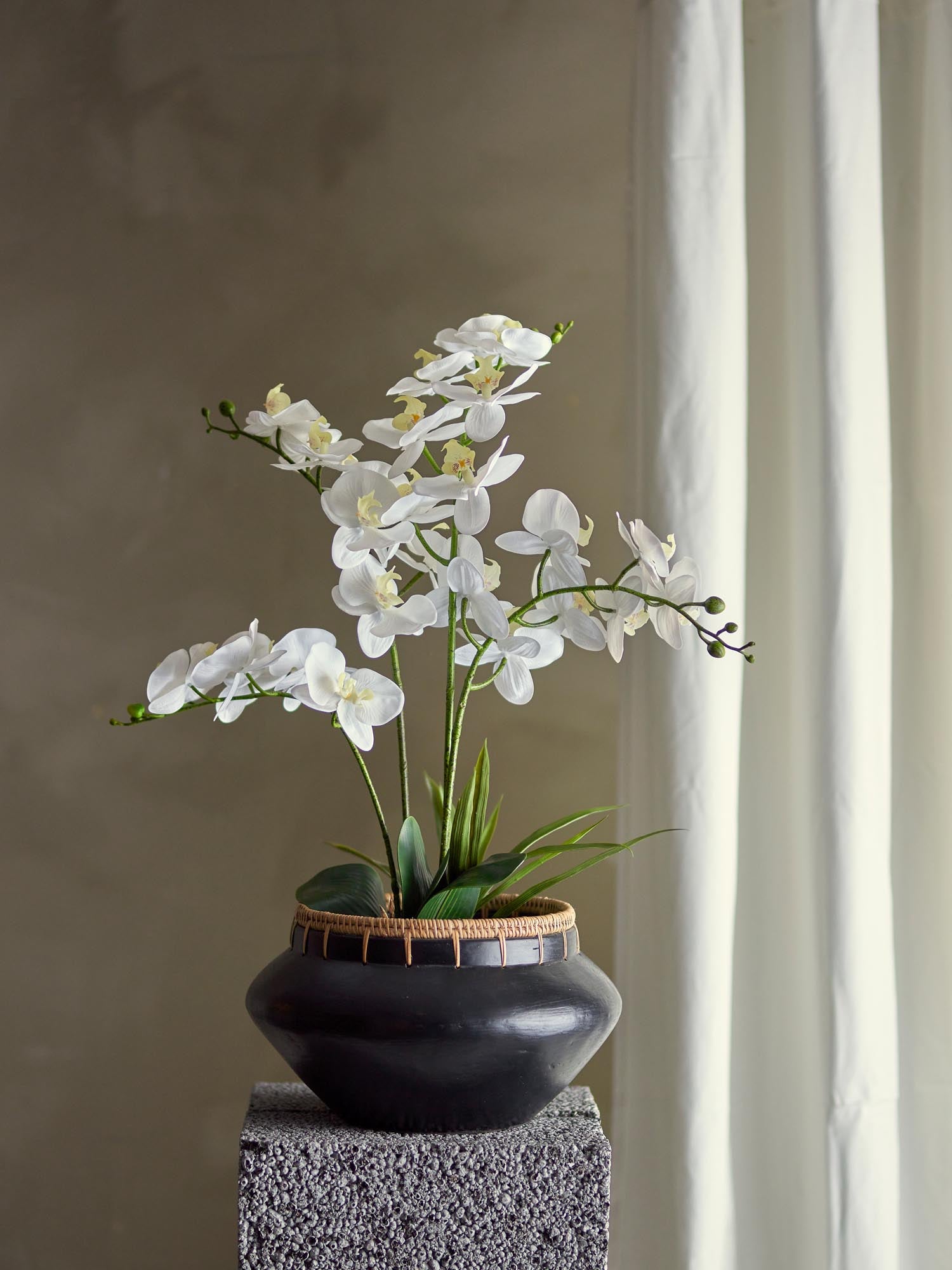 Elegante künstliche Orchidee von Bloomingville, grüne Blätter und realistische Blüten, ideal für stilvolle Dekoration.