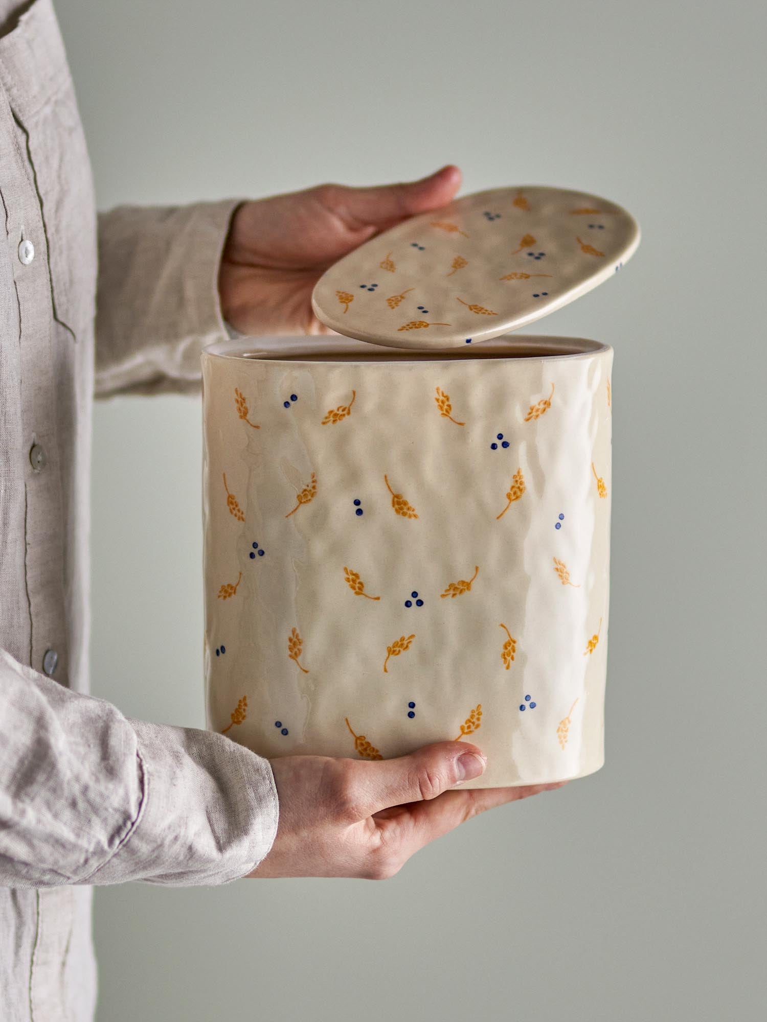 Elegantes, weisses Steingut-Gefäss mit Deckel, verziert mit gold-blauen Details, ideal für stilvolle Aufbewahrung.