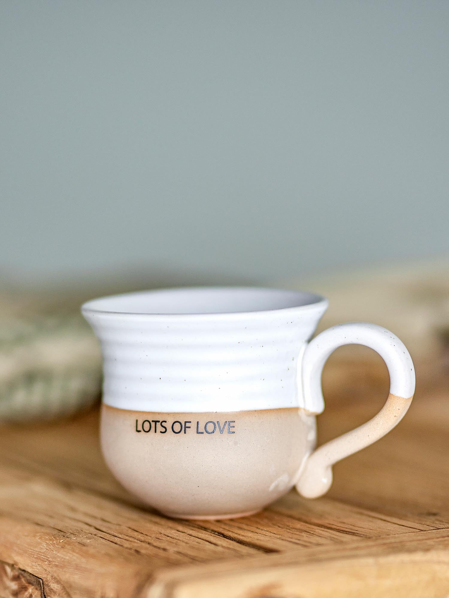 Elegante Claire Tasse aus weissem Steingut mit "Lots of love"-Schriftzug, robust und spülmaschinenfest.