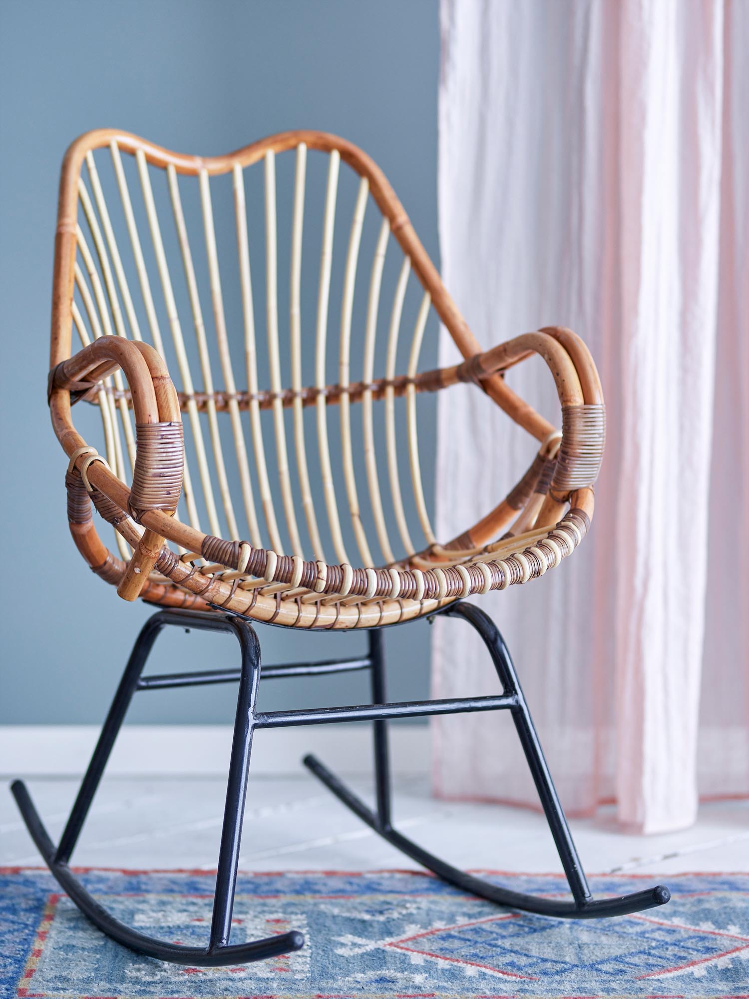 Ein stilvoller Schaukelstuhl aus natürlichem Rattan, perfekt für gemütliche Momente und ein modernes, skandinavisches Ambiente.