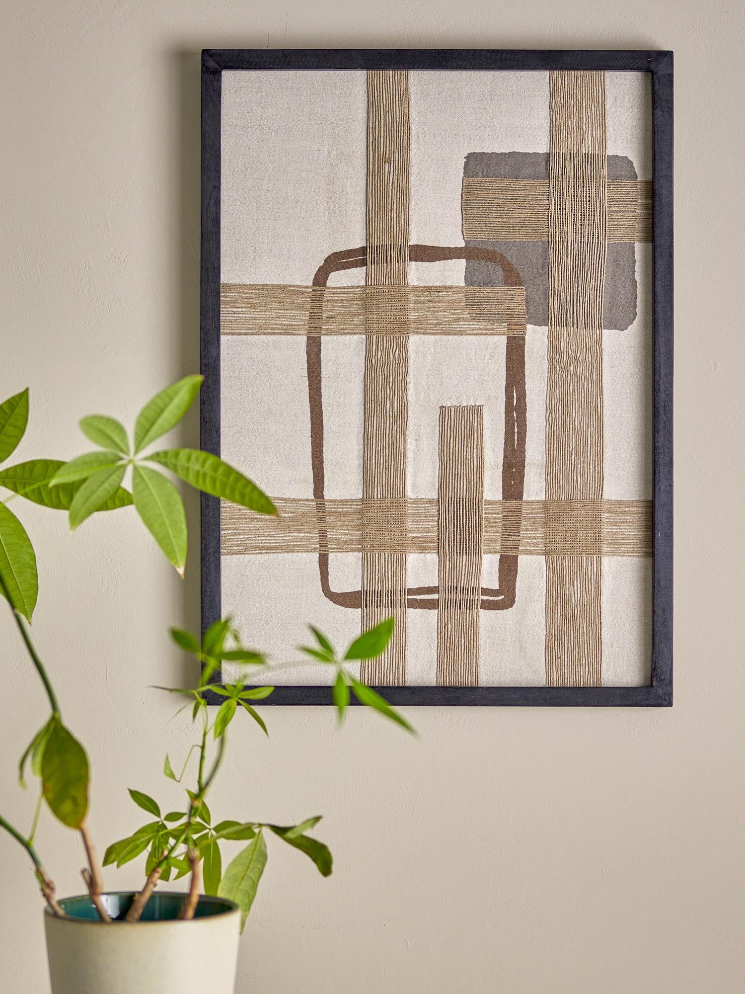 Die Bie Wanddekoration von Bloomingville: Ein modernes Kunstwerk aus Baumwolle, das mit warmen Brauntönen und geometrischen Formen besticht.