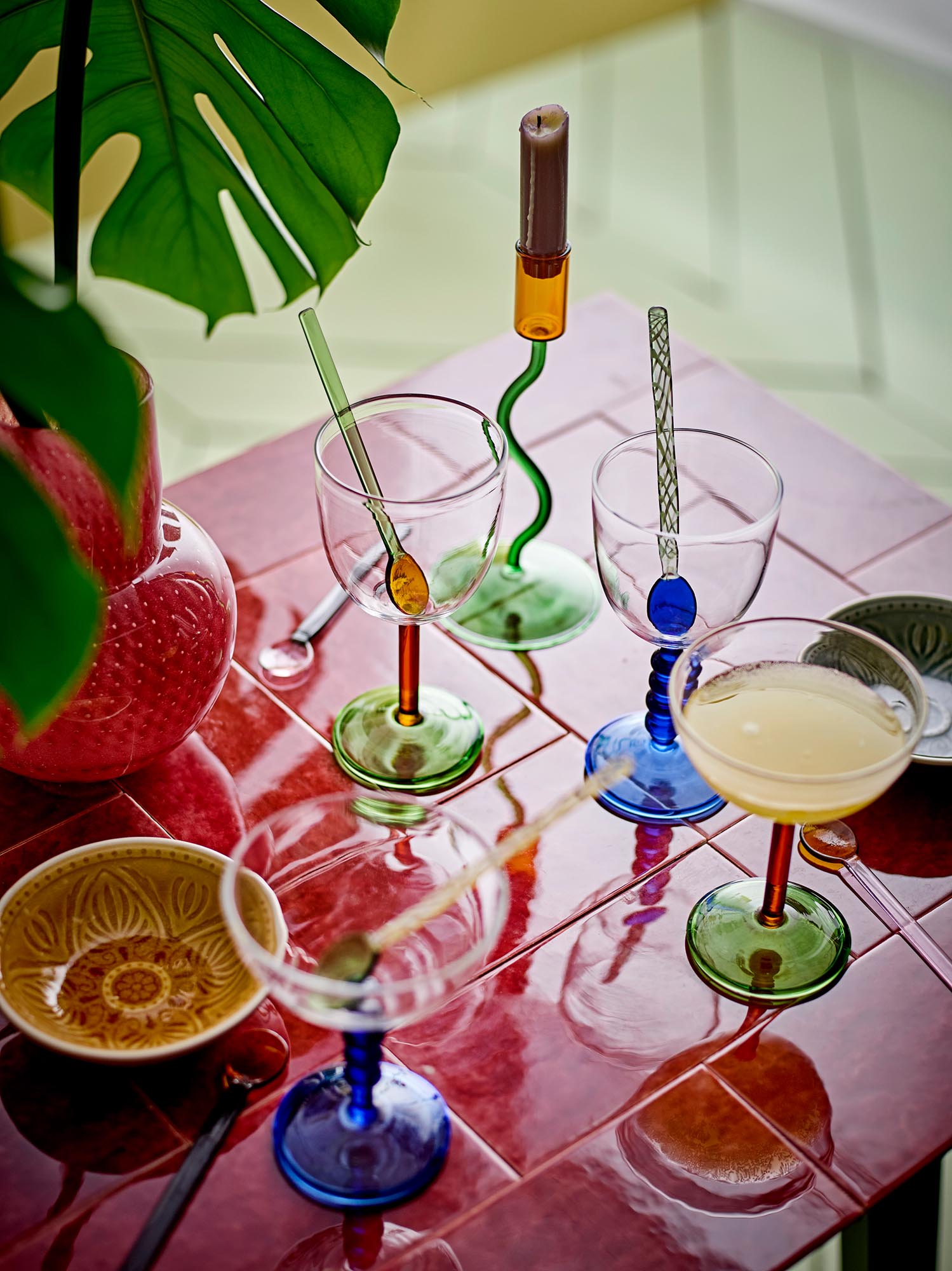 Elegantes Cocktailglas mit rotem Stiel und grünem Fuss, ideal für stilvolle Drinks. Perfekt für besondere Anlässe.
