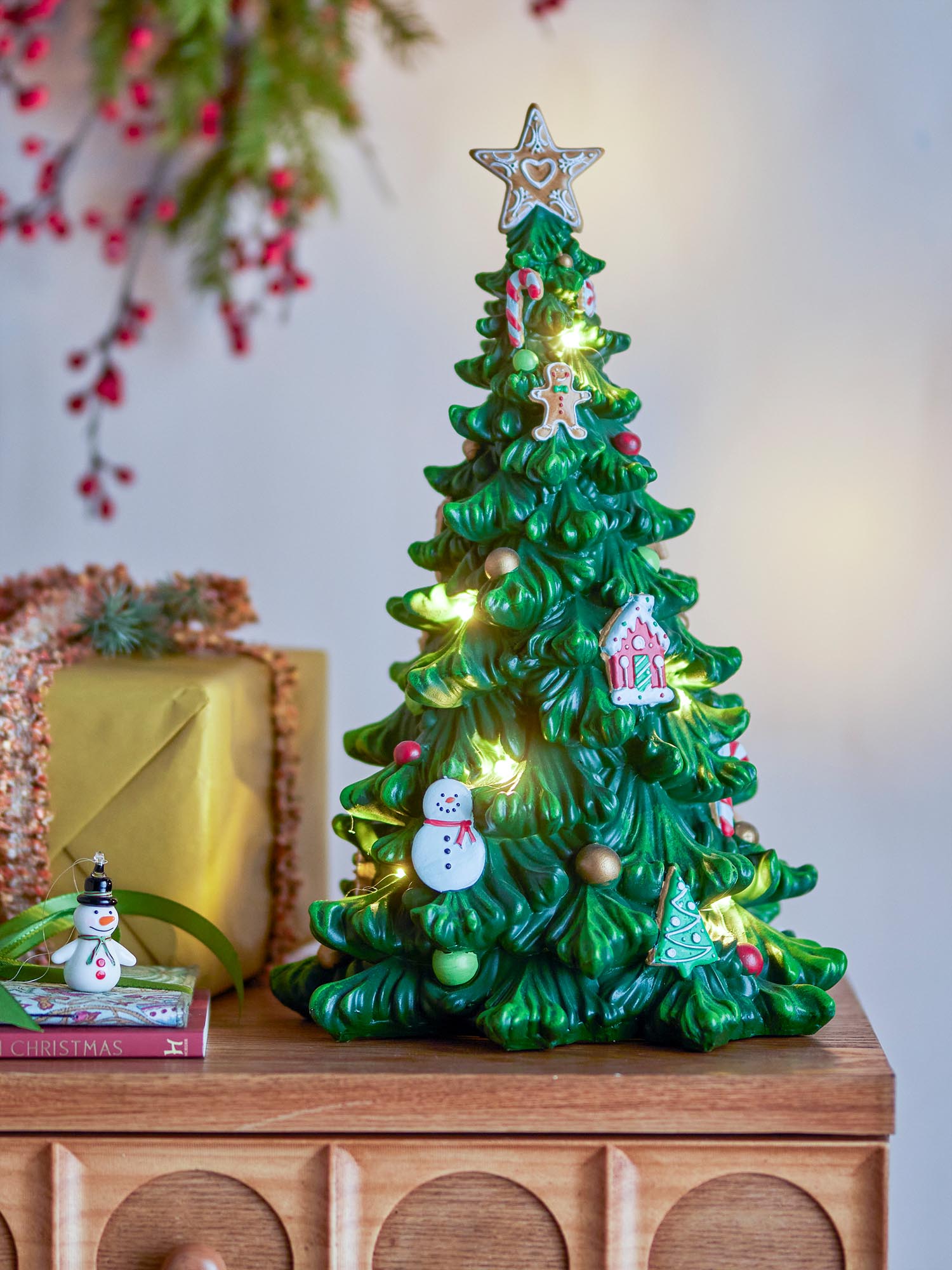 Ein stilvoller, grüner Polyresin-Weihnachtsbaum mit sanftem Licht, der festliche Eleganz und Gemütlichkeit ausstrahlt.
