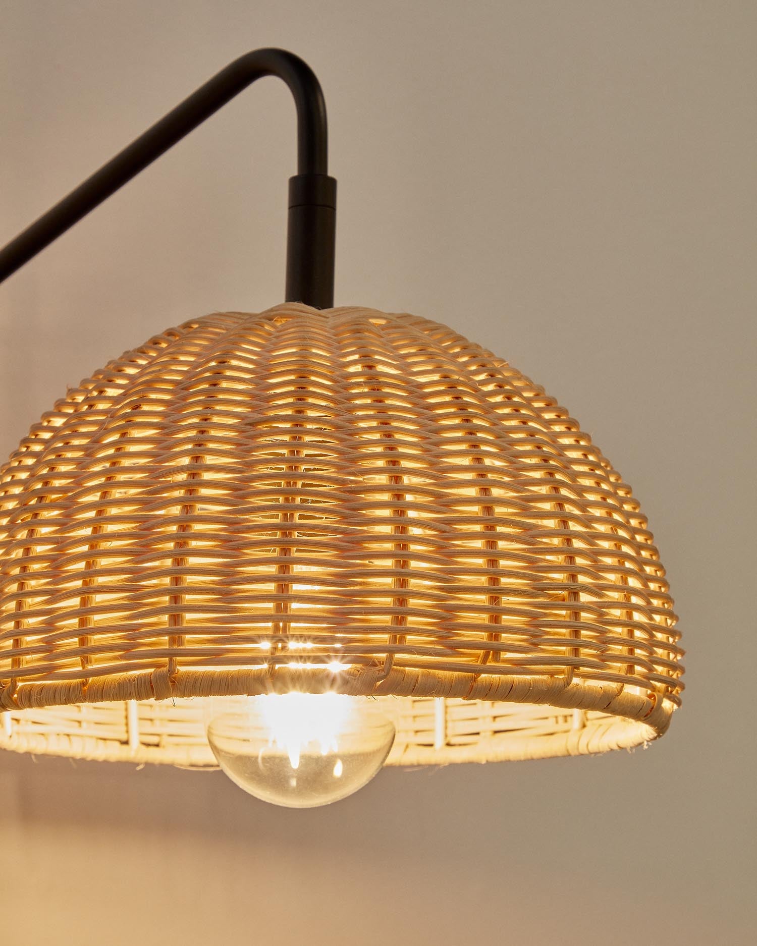 Die Damila Wandleuchte von Kave Home vereint stilvolles schwarzes Metall und handgefertigtes Rattan für ein einzigartiges Wohnambiente.