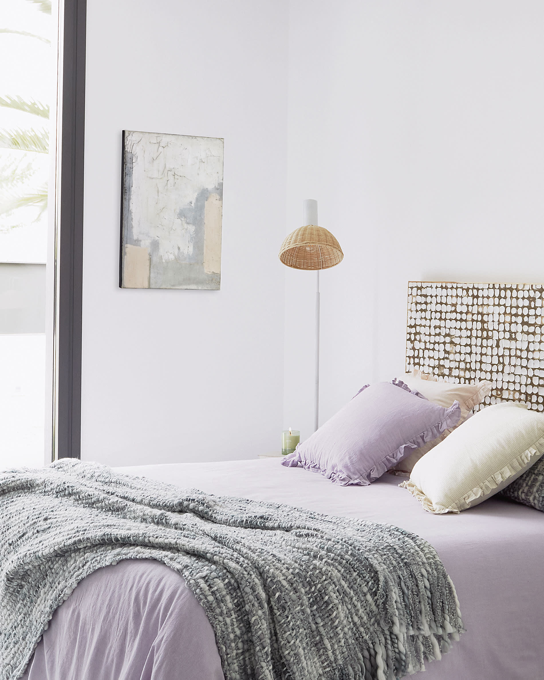 Elegante Stehlampe aus weissem Metall und handgeflochtenem Rattan, die Wärme und Stil in jeden Raum bringt.