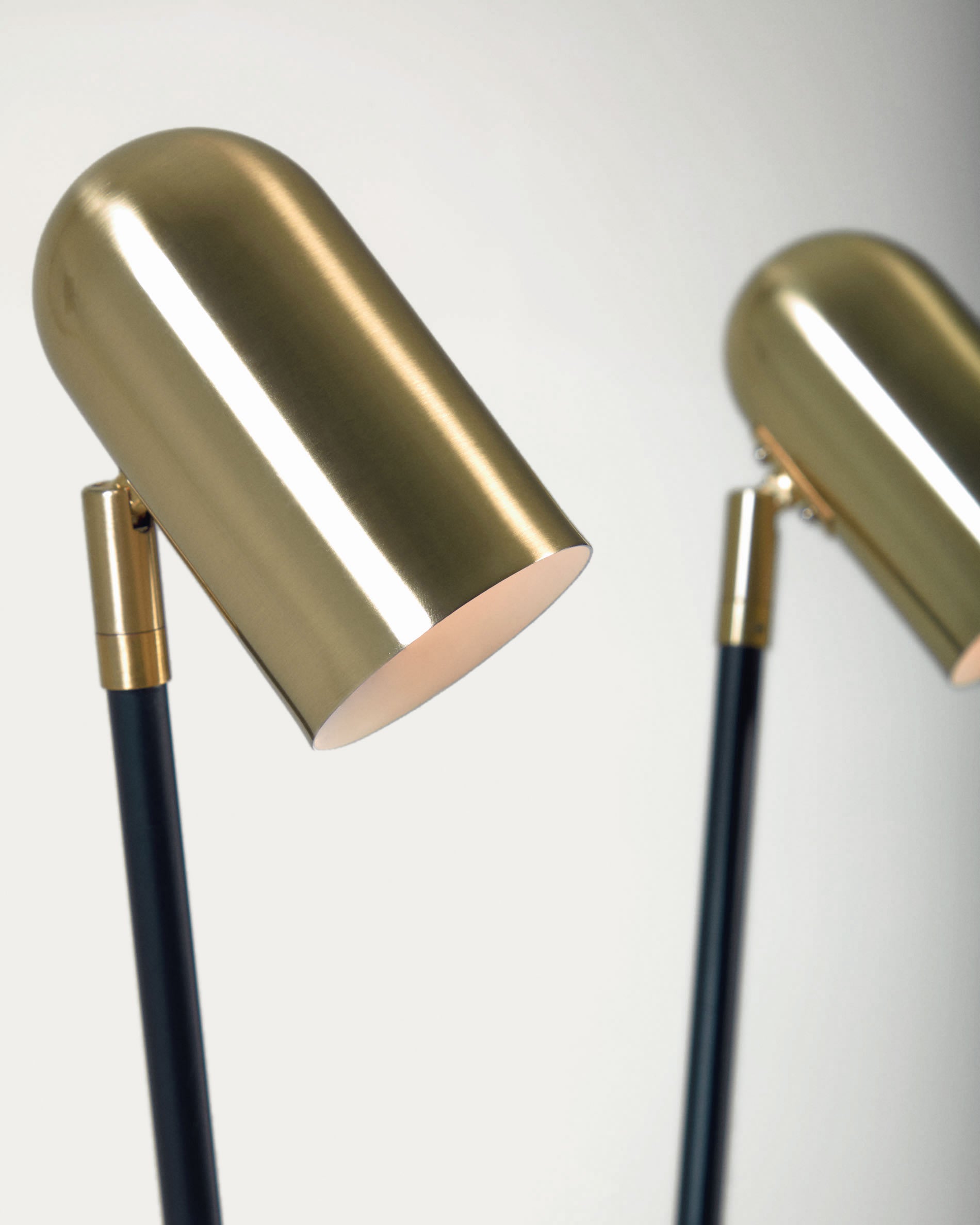 Die Clemence Stehlampe von Kave Home vereint modernes Design aus schwarzem Metall mit luxuriösen goldenen Schirmen und schafft eine einladende Atmosphäre.