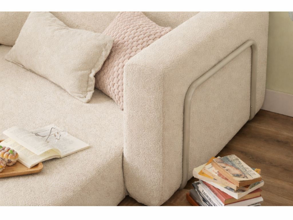 Cremefarbenes 1-Sitzer Schlafsofa Wello aus Bouclé-Stoff mit kompakter Sitzfläche und ausklappbarer Liegefläche im Wohnraum.