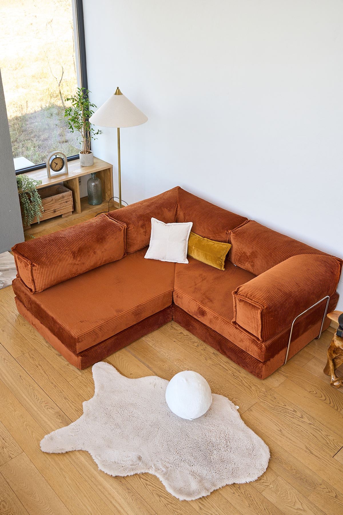 Ziegelrotes Ecksofa-Bett aus geripptem Cord-Plüschstoff mit vier Kissen, abnehmbarem Bezug und Roll-Pack-Funktion von Hanah Home.