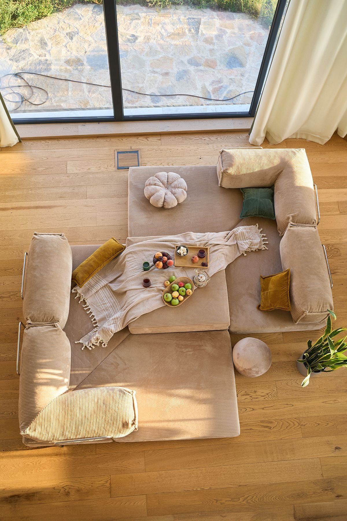Beiges Eck-Schlafsofa Kanyon von Hanah Home aus geripptem Cord-Plüschstoff, L-Form mit vier Kissen, auf hellem Untergrund fotografiert.