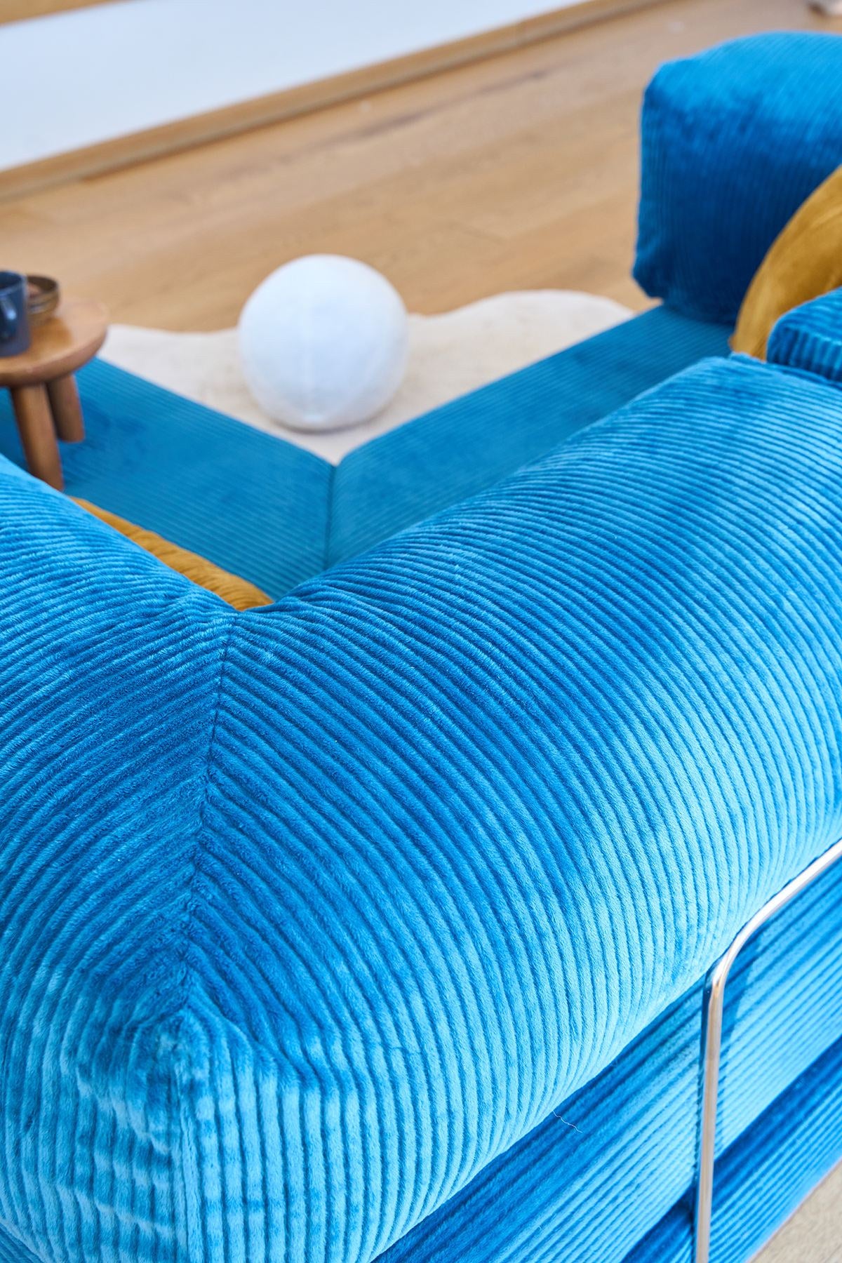 Kanyon Eck-Schlafsofa in Indigo von Hanah Home aus geripptem Cord-Plüschstoff, L-Form mit vier mitgelieferten Kissen.