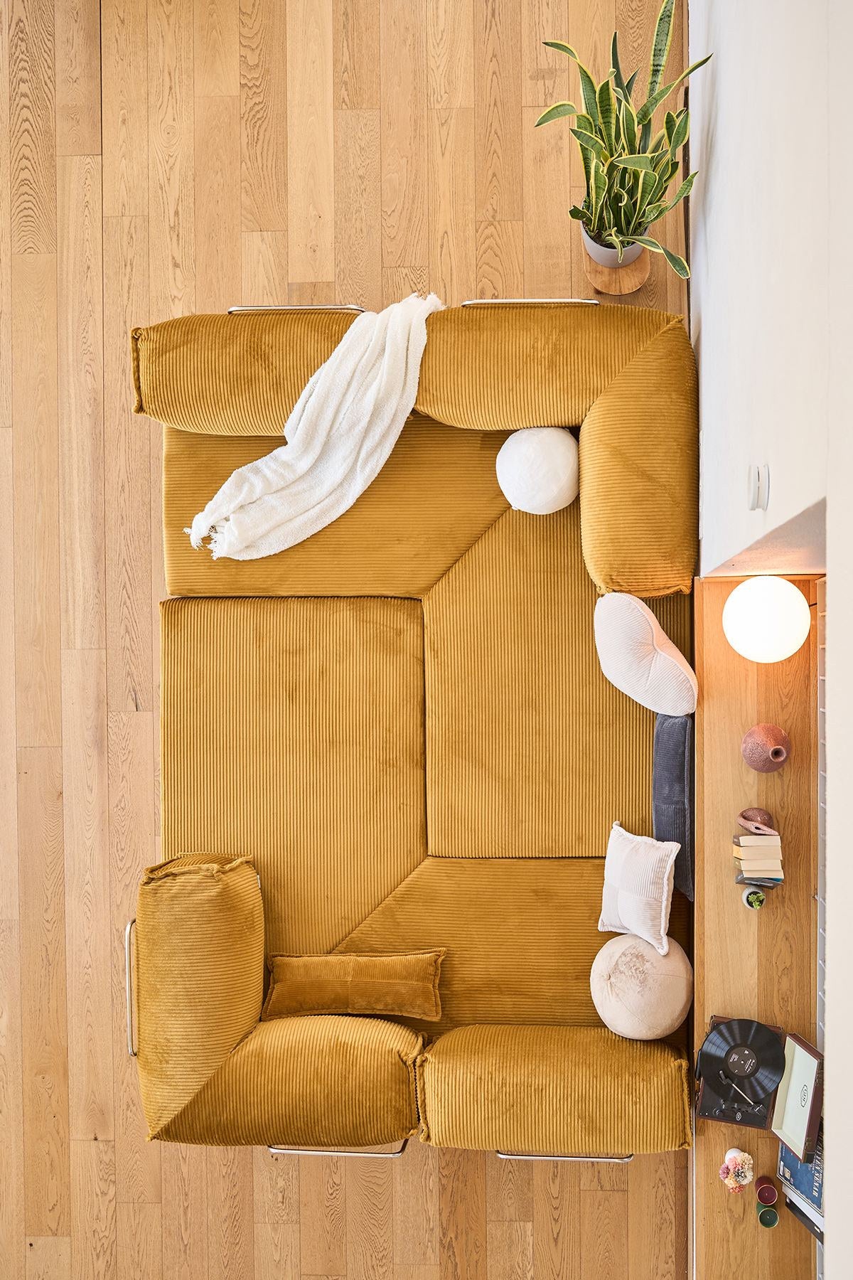 Senfgelbes Eck-Schlafsofa Kanyon von Hanah Home aus geripptem Cord-Plüschstoff mit vier Kissen und rutschfester Sohle.