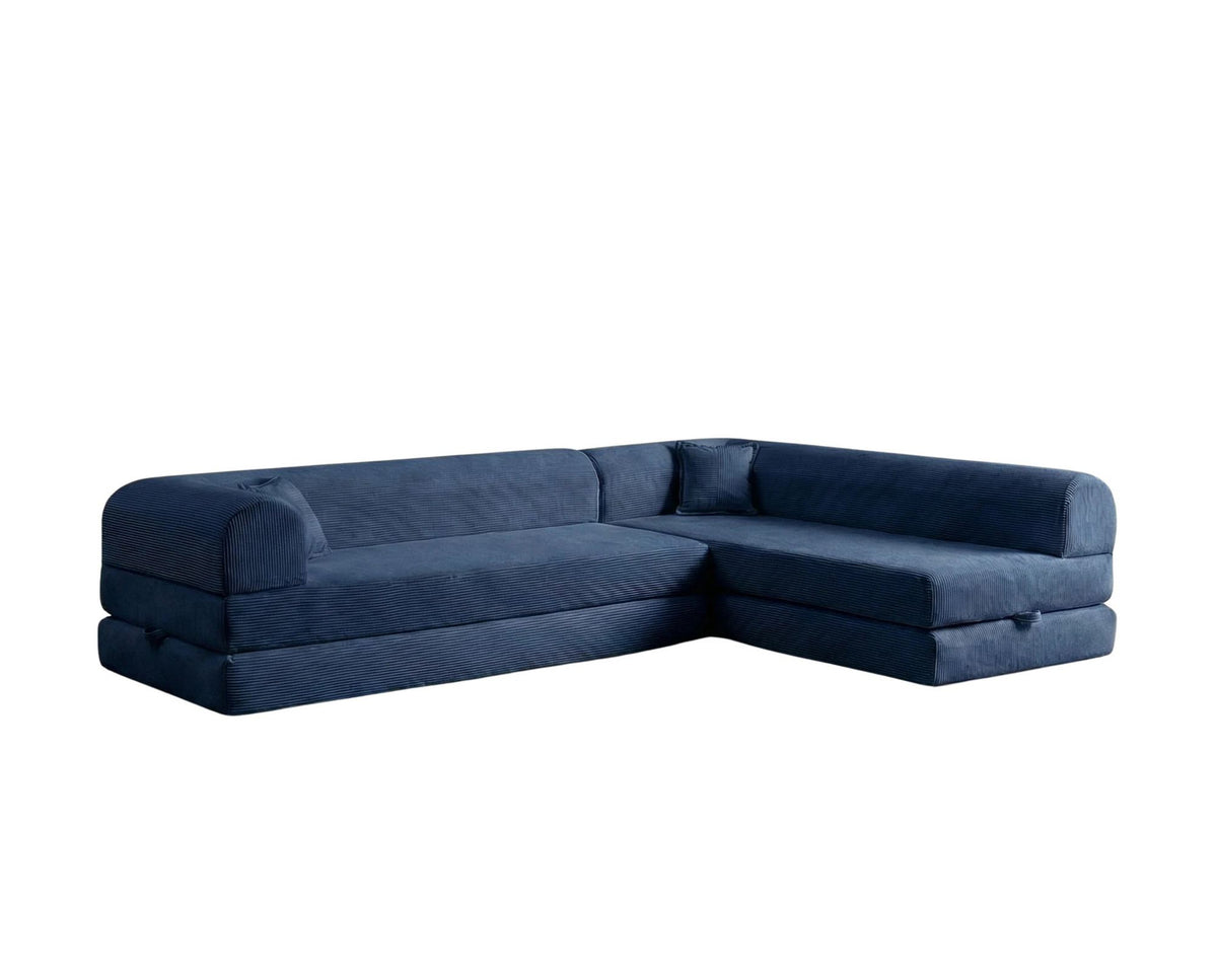Marineblaues Ecksofa-Bett mit Cord-Plüschbezug, vier Kissen, Rückenlehne und niedriger Sitzhöhe, freistehend im Raum fotografiert.