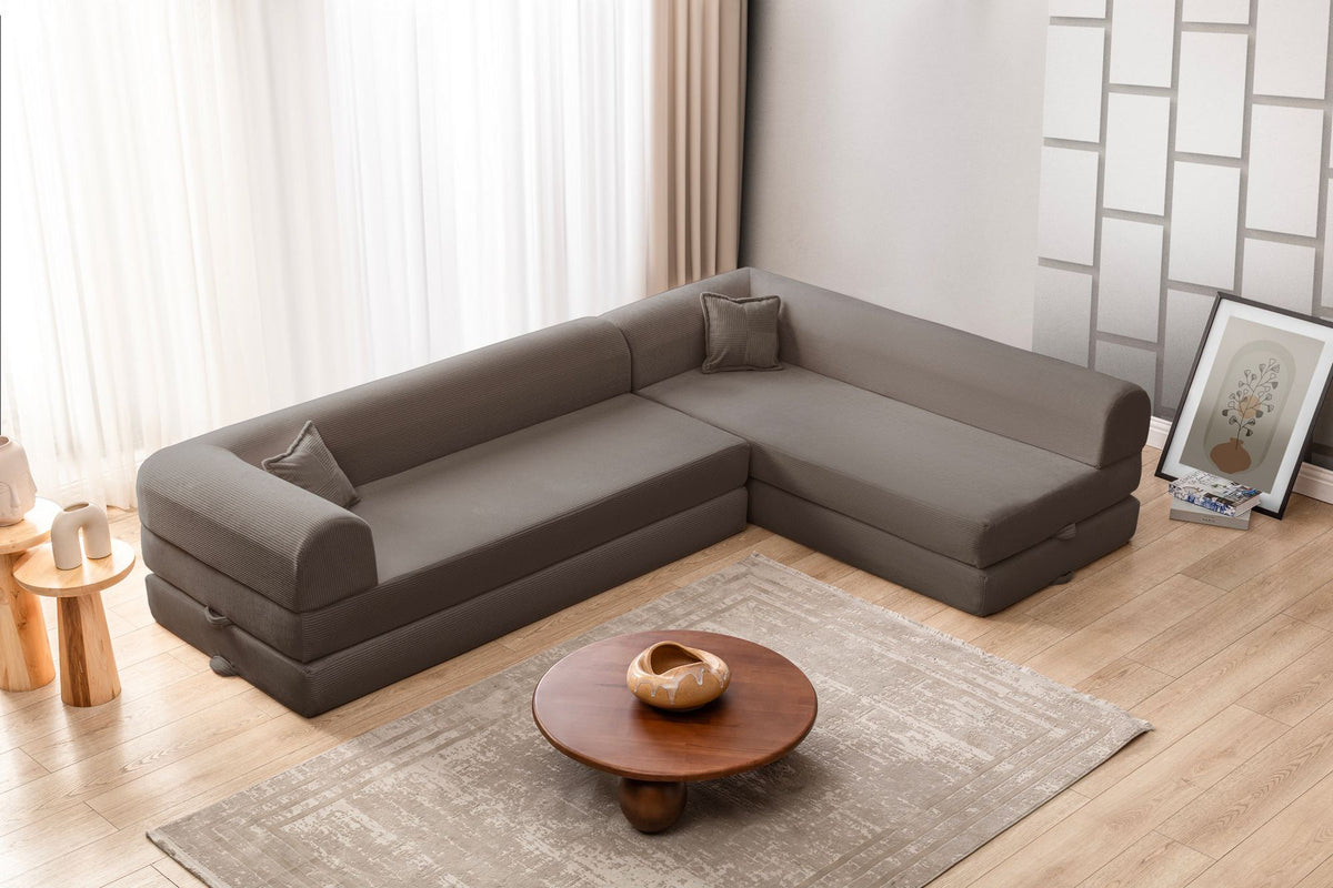 Braunes Ecksofa-Bett Legom Eco von Hanah Home aus geripptem Plüschstoff mit vier Kissen und abnehmbarem Bezug, Frontalansicht.