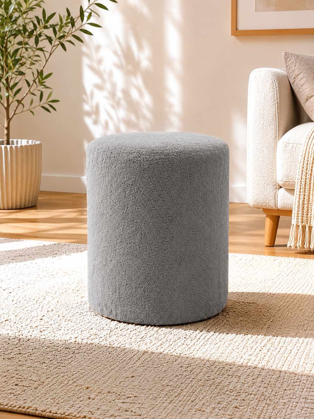 Runder grauer Pouf mit Wellsoft-Bezug, gepolsterter Sitzfläche und Kunststoffbeinen, Durchmesser 40 cm, Höhe 45 cm, freigestellt fotografiert.
