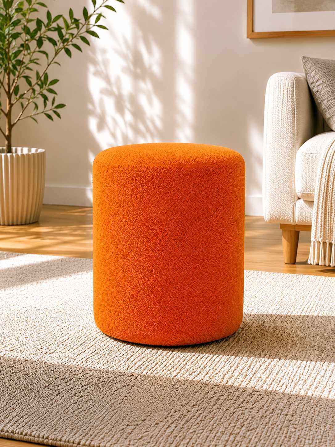 Runder oranger Pouf mit Wellsoft-Stoffbezug, Spanplatten-Sitzfläche und kurzen Kunststoffbeinen, Durchmesser 40 cm, Höhe 45 cm.
