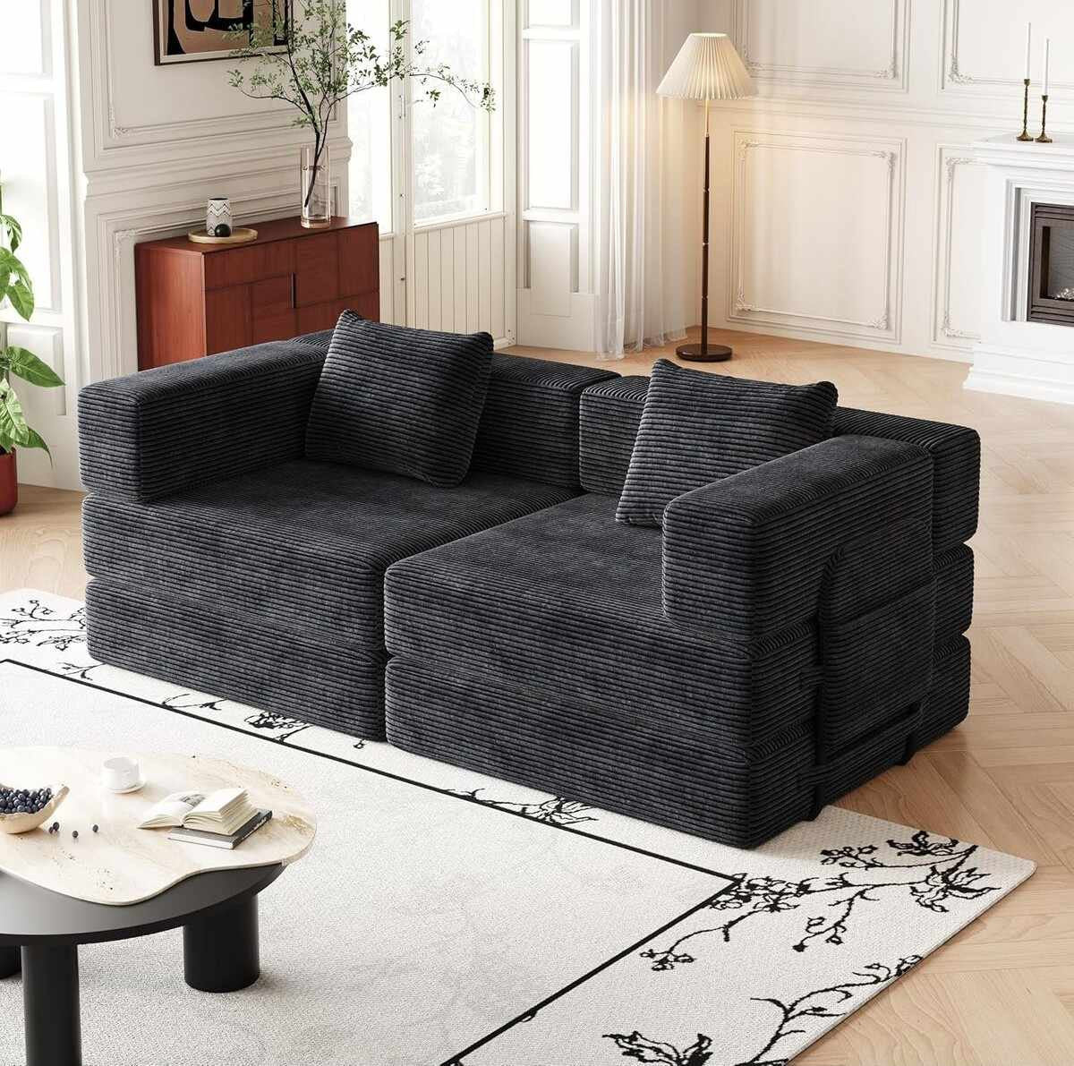 Schwarzes 3-Sitzer Schlafsofa aus Polyester-Leinen-Stoff mit zwei Kissen, schlichtes Design, ausgeklappt als Liegefläche sichtbar.