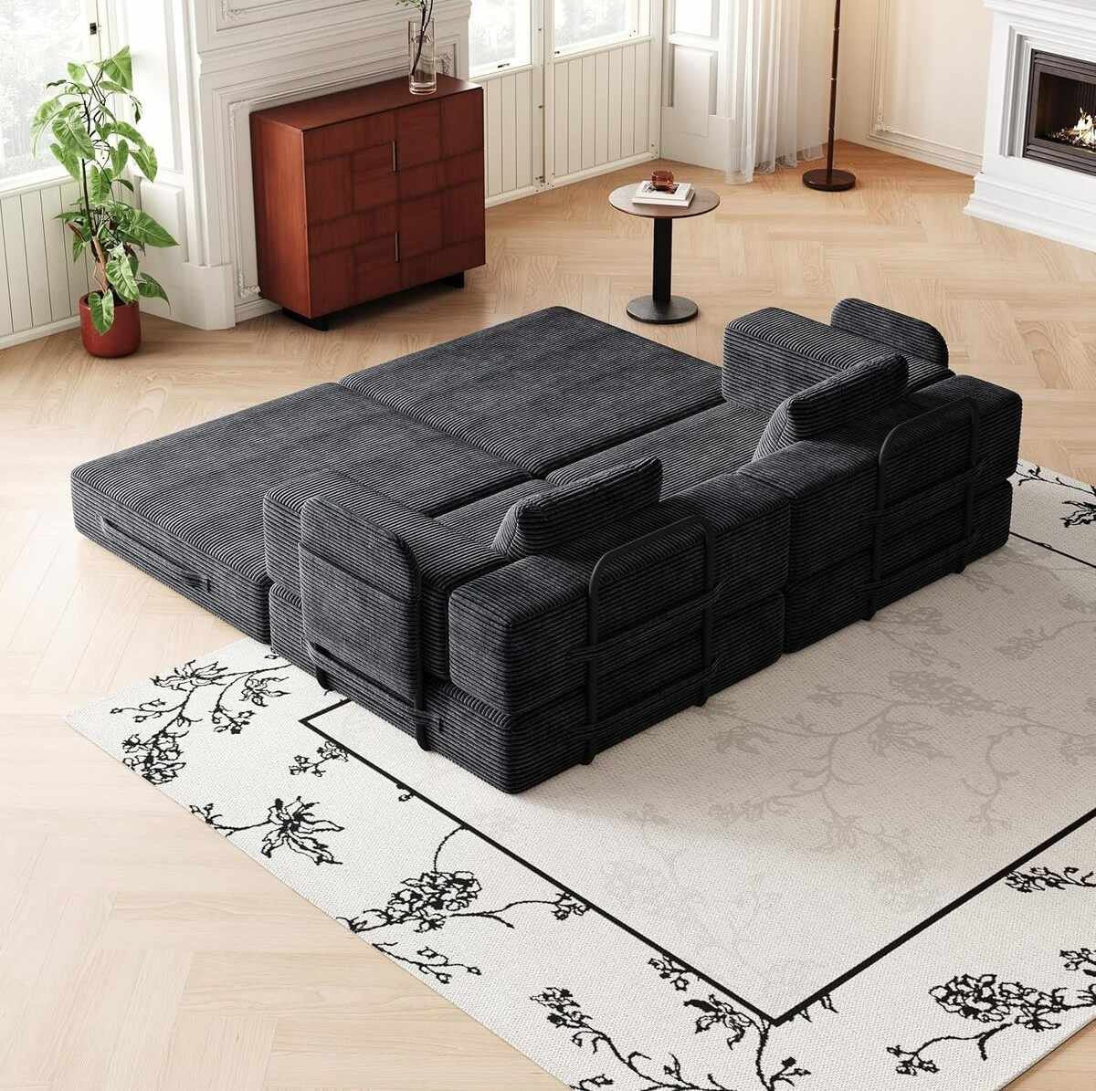Schwarzes 3-Sitzer Schlafsofa aus Polyester-Leinen-Stoff mit zwei Kissen, schlichtes Design, ausgeklappt als Liegefläche sichtbar.