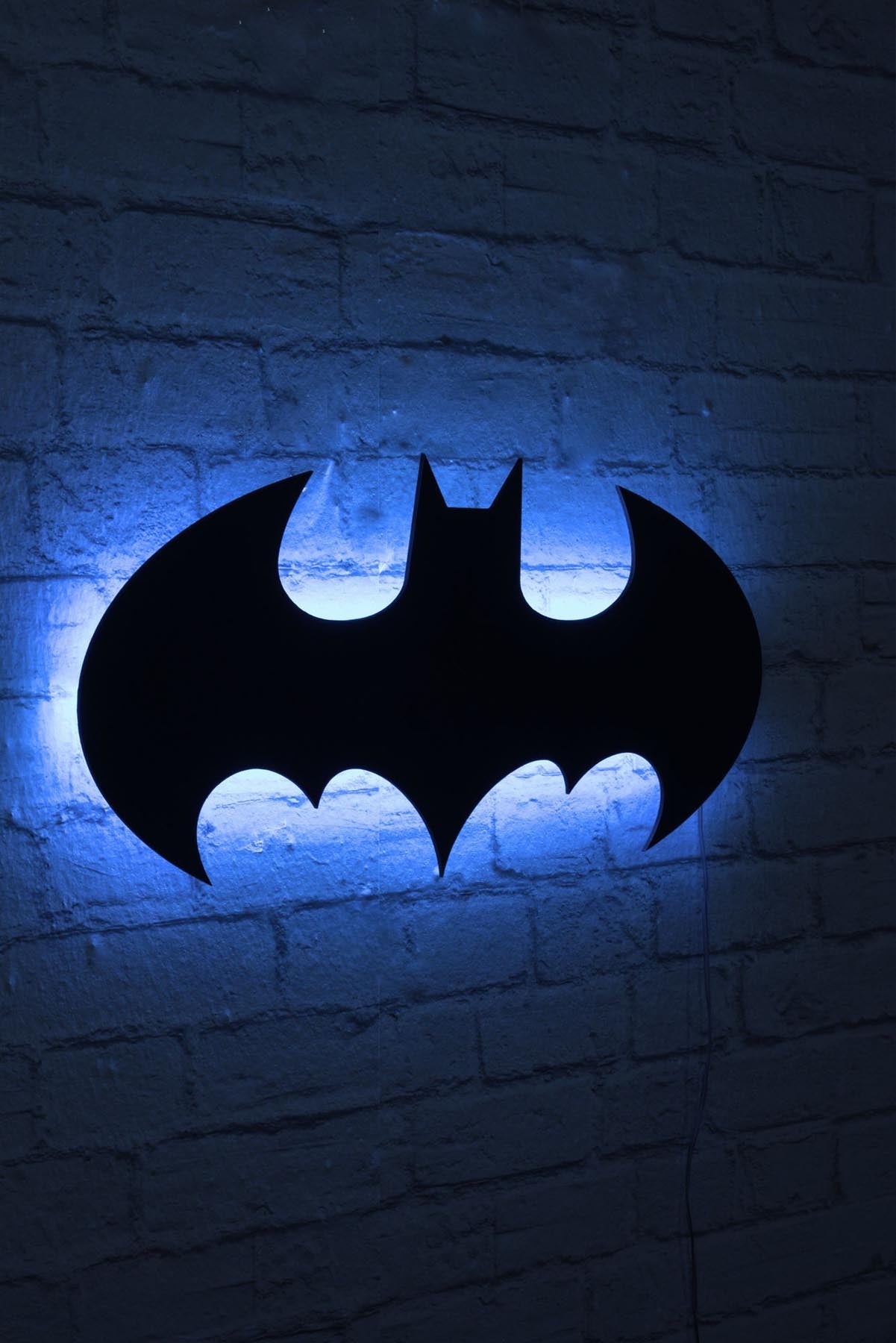 Entdecken Sie die Batman Wandleuchte in Blau von Wallity – eine stilvolle LED-Beleuchtung, die jeden Raum mit sanftem Licht und Charme erfüllt.
