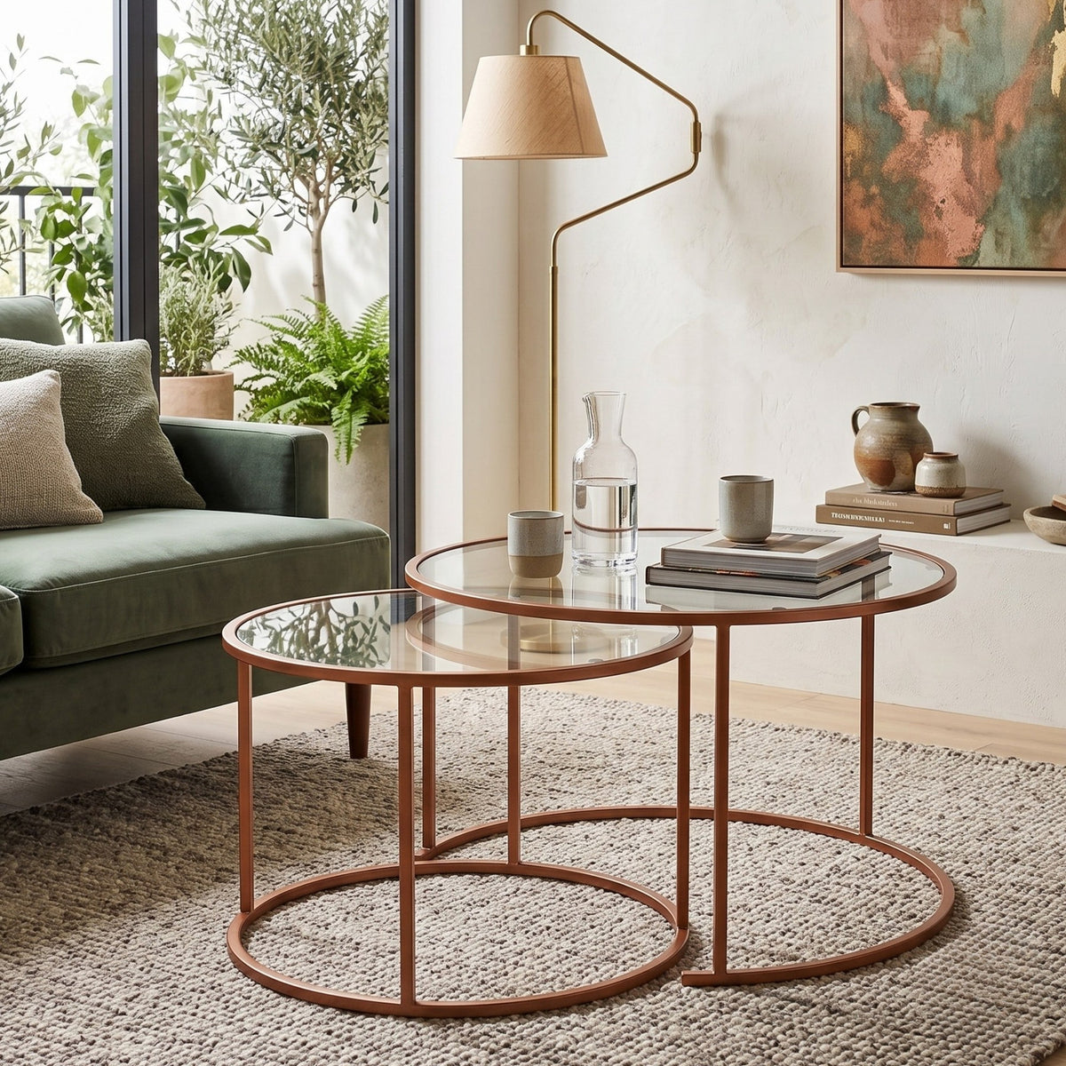 Zwei orangefarbene Couchtische von Hanah Home mit Platten aus gehärtetem Glas und schlankem Metallgestell, unterschiedlich gross, freigestellt.