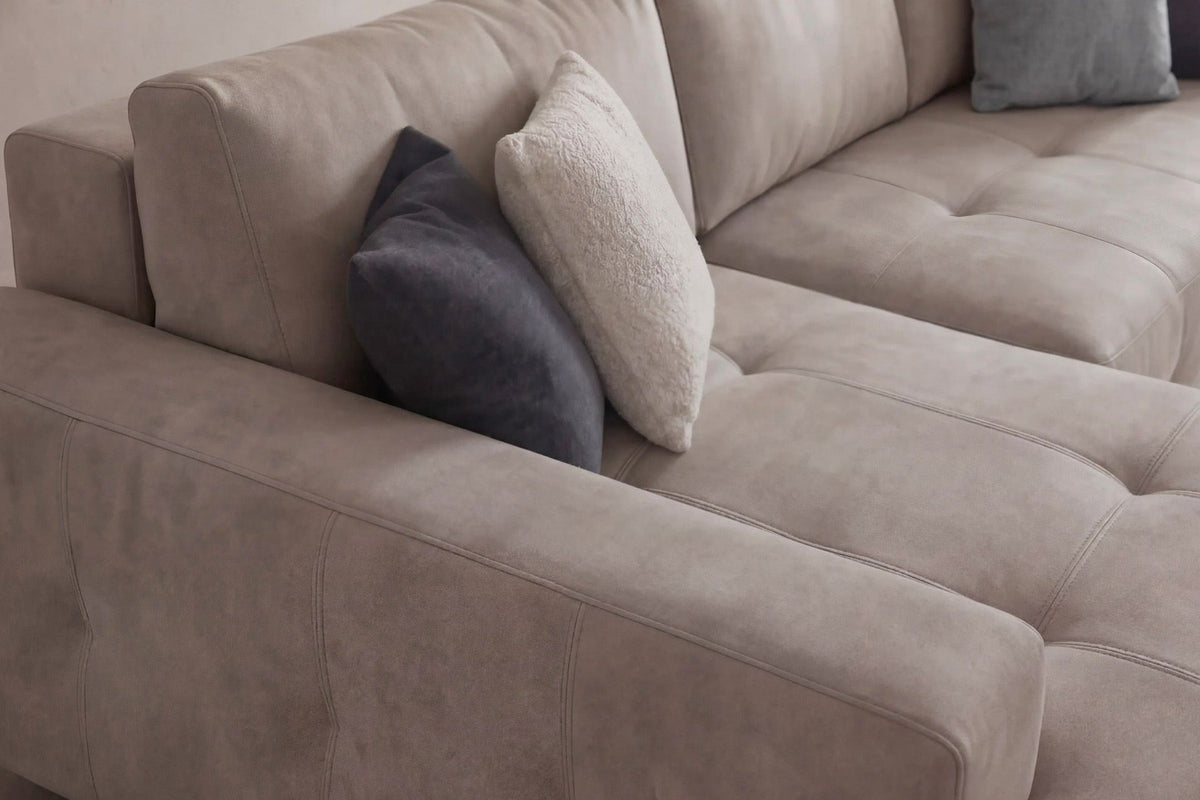Beiges Eck-Schlafsofa Magnum von Hanah Home mit Polyesterbezug, Buchenholzgestell, Kunststoffbeinen und zwei losen Kissen, links ausgerichtet.