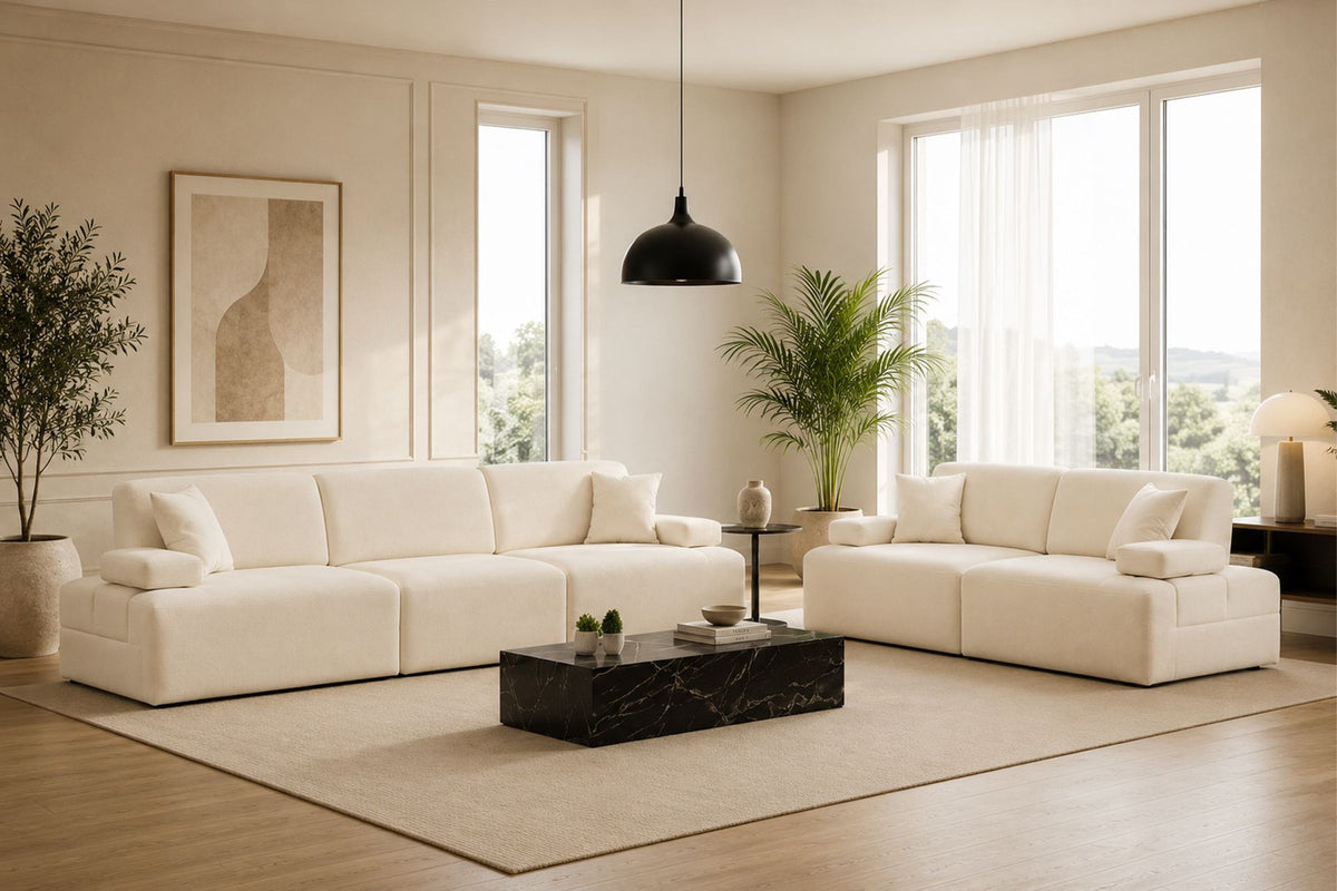 Cremefarbenes 3-Sitzer Sofa aus Polyesterstoff mit Buchenholzgestell, niedrigen Kunststoffbeinen und zwei Kissen.
