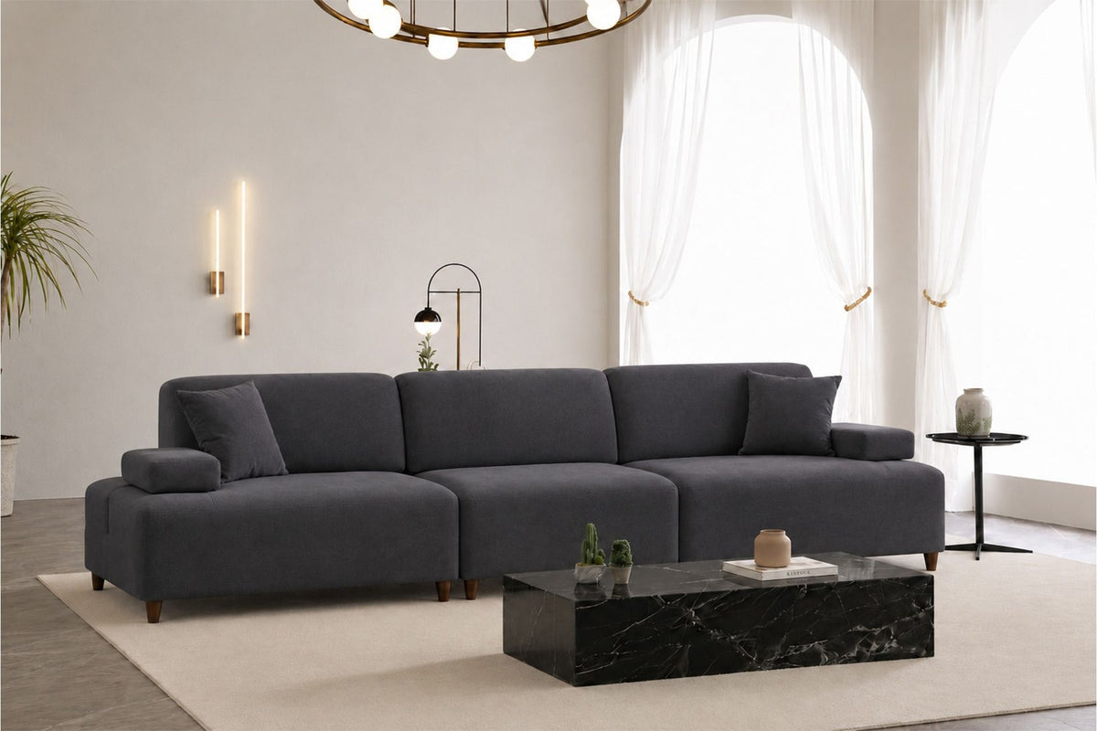 Petrolblaues 4-Sitzer-Sofa Madlen von Hanah Home mit hohen Kunststoffbeinen, Polyesterbezug, Holzgestell und zwei losen Kissen.