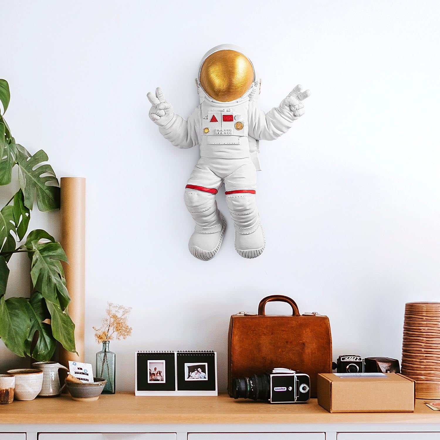Verleihen Sie Ihrem Zuhause mit der stilvollen Wanddeko "Peace Sign Astronaut" von Wallity in Weiß und Gold einen einzigartigen Charme!