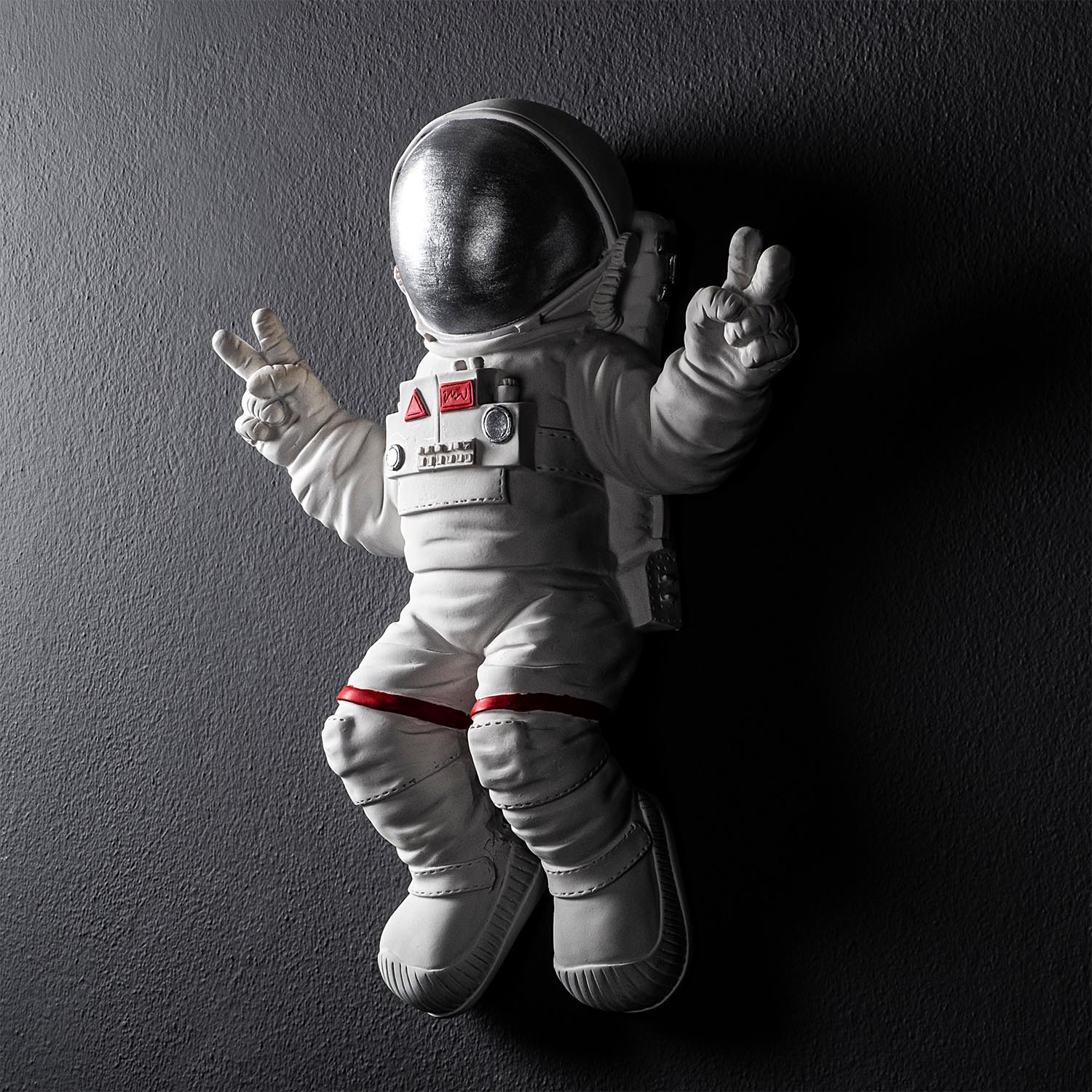 Verleihen Sie Ihrem Raum mit der einzigartigen Wanddeko "Peace Sign Astronaut" in Weiß und Grau von Wallity einen Hauch von Eleganz und Stil.