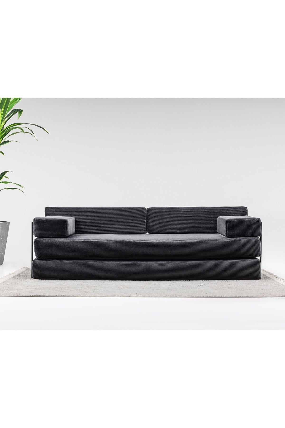 3-Sitzer-Schlafsofa in Anthrazit aus Venom Samt mit geraden Armlehnen, verstellbarer Rückenlehne und abnehmbaren Sitzkissen im Wohnraum.