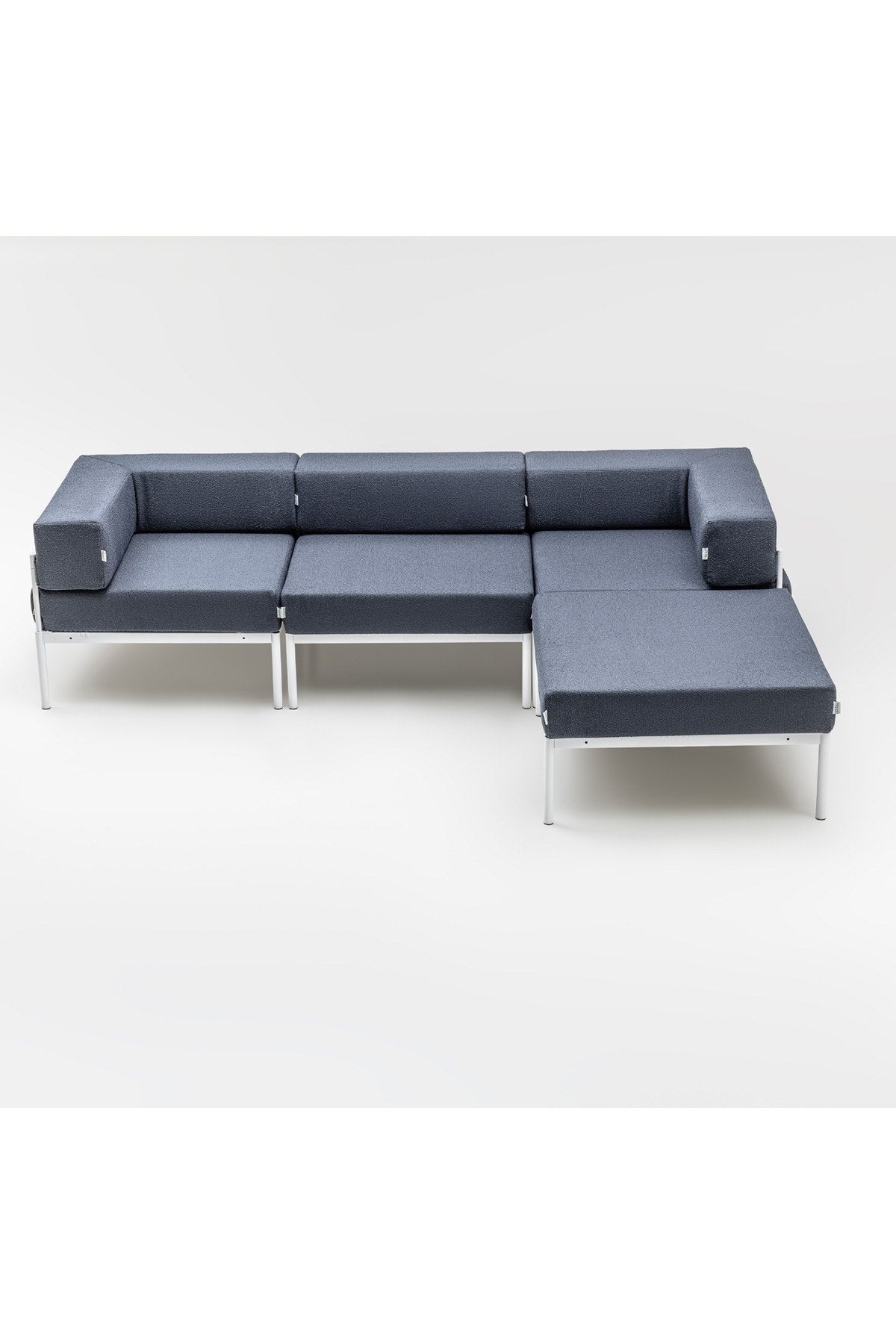 Weisses Ecksofa mit marineblauen Elementen, Bouclé-Stoff, Metallbeine, breite Sitzfläche und verstellbare Rückenlehne im Wohnzimmer.