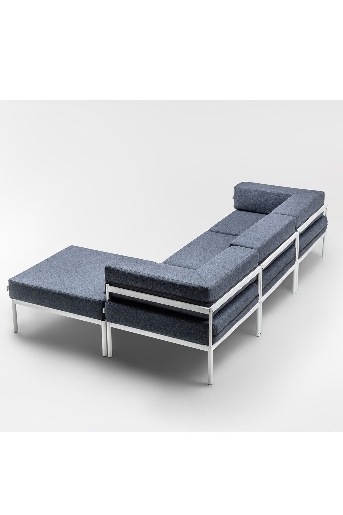 Weisses Ecksofa mit marineblauen Elementen, Bouclé-Stoff, Metallbeine, breite Sitzfläche und verstellbare Rückenlehne im Wohnzimmer.
