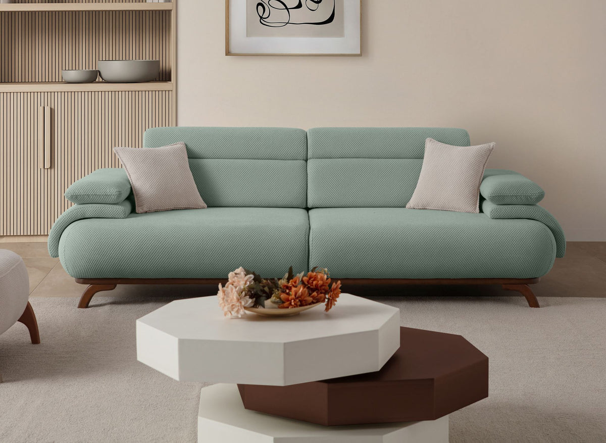 Seegrünes 3-Sitzer Sofa Bonjo von Hanah Home mit Holzbeinen, Polyesterbezug in Tuna-Struktur und zwei losen Kissen auf hellem Hintergrund.