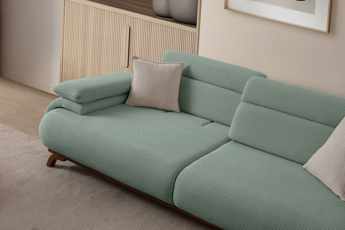 Seegrünes 3-Sitzer Sofa Bonjo von Hanah Home mit Holzbeinen, Polyesterbezug in Tuna-Struktur und zwei losen Kissen auf hellem Hintergrund.