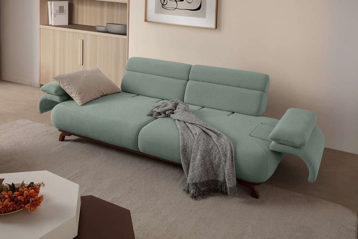 Seegrünes 3-Sitzer Sofa Bonjo von Hanah Home mit Holzbeinen, Polyesterbezug in Tuna-Struktur und zwei losen Kissen auf hellem Hintergrund.
