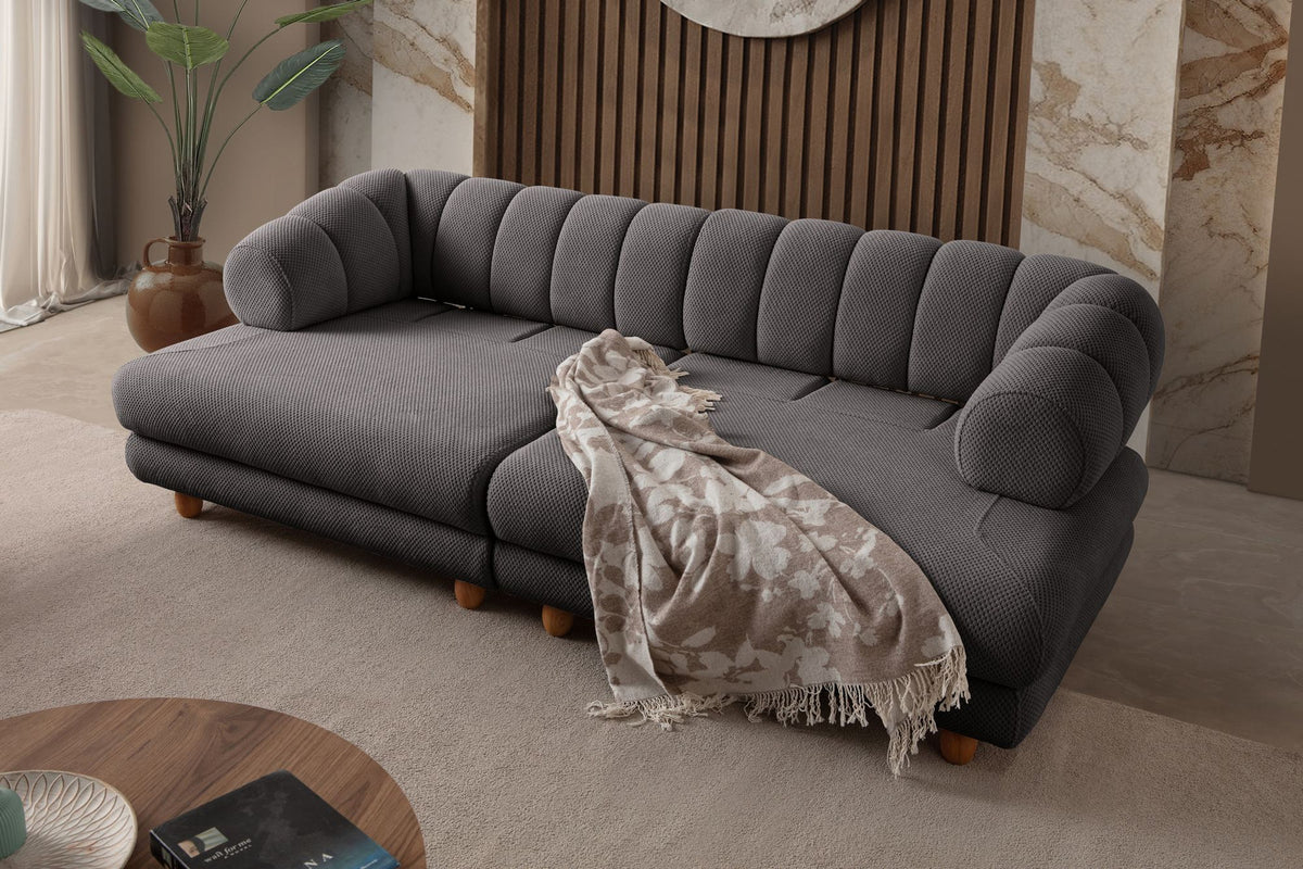 Anthrazitfarbenes 3-Sitzer Sofa mit Polyesterbezug in Tuna-Struktur, Holzbeinen und zwei losen Kissen auf hellem Untergrund.