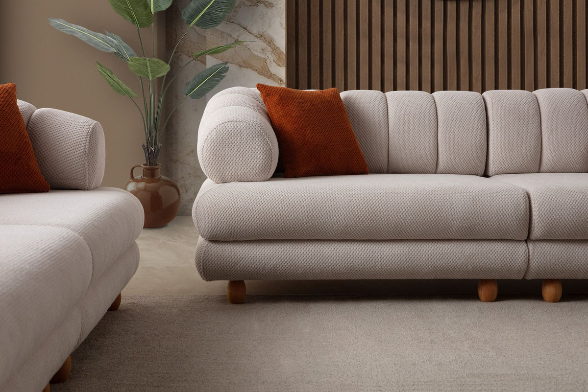 Beiges 3-Sitzer Sofa Gloria von Hanah Home mit Polyesterbezug, Holzbeinen und zwei Kissen, Frontalansicht auf hellem Hintergrund.