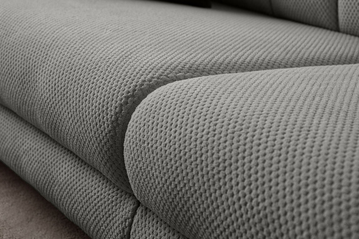 Graues 3-Sitzer Sofa Gloria von Hanah Home mit Polyesterbezug in Tuna-Struktur, Holzbeinen und zwei losen Kissen auf hellem Untergrund.