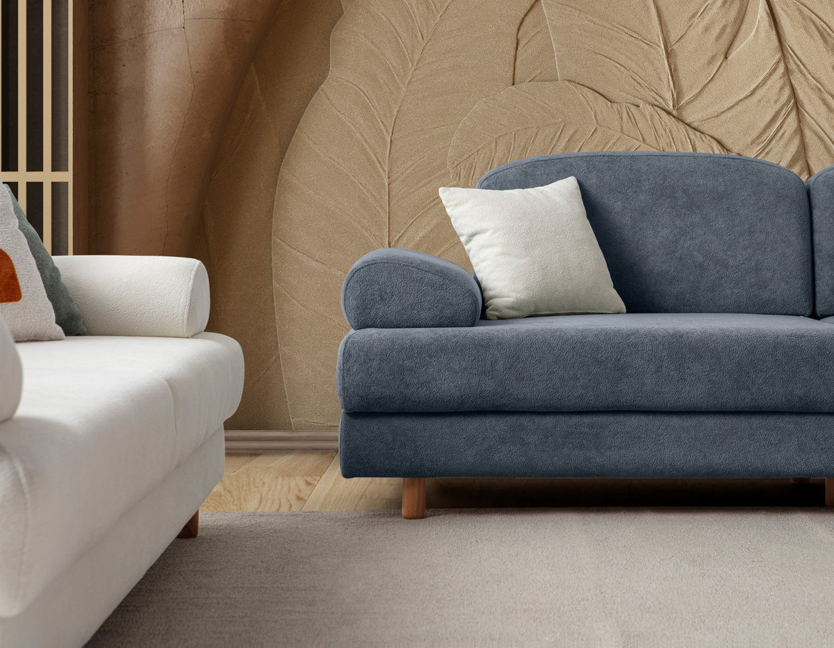 Blaues 3-Sitzer Schlafsofa Aries von Hanah Home mit Coco-Boucle-Stoff, Holzbeinen und drei Kissen, Frontalansicht im Wohnraum.