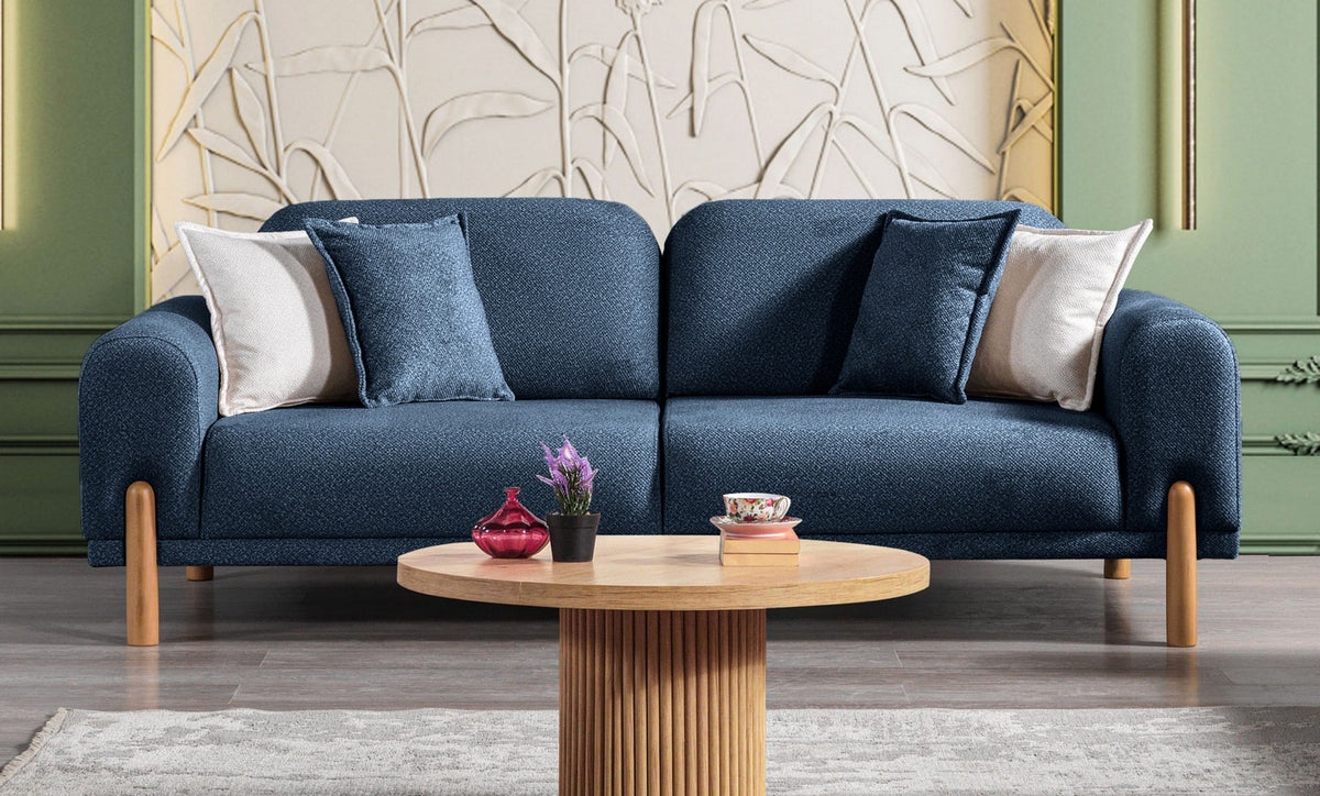 Marineblaues 3-Sitzer Schlafsofa Class Bohem mit flauschigem Bouclé-Bezug, Holzbeinen und vier Kissen, fotografiert auf hellem Hintergrund.