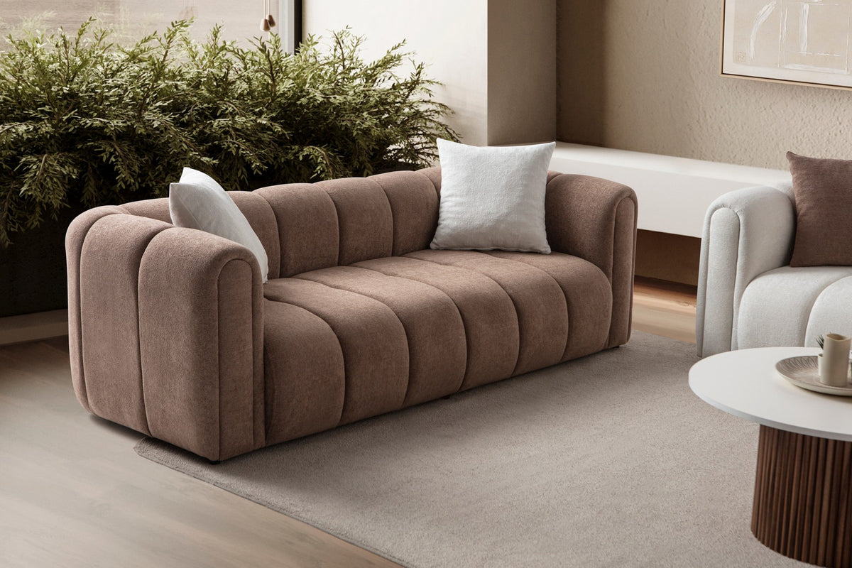 Braunes 3-Sitzer Sofa mit Boucle-Bezug, Hainbuche-Gestell, Kunststoffbeinen und zwei losen Kissen, fotografiert im Wohnraum.