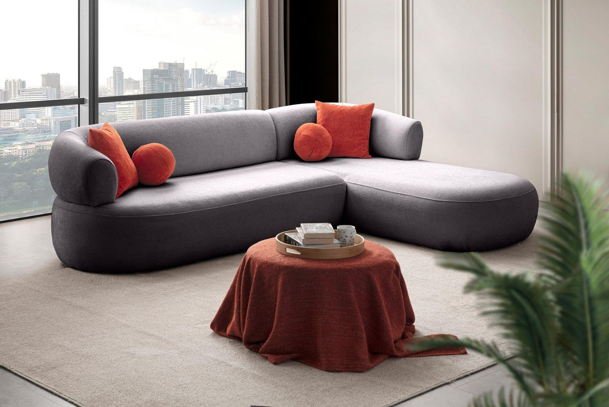 Dunkelgraues Roma Ecksofa rechts von Hanah Home mit Boucle-Stoff, Kunststoffbeinen und vier passenden Kissen im Wohnzimmer.