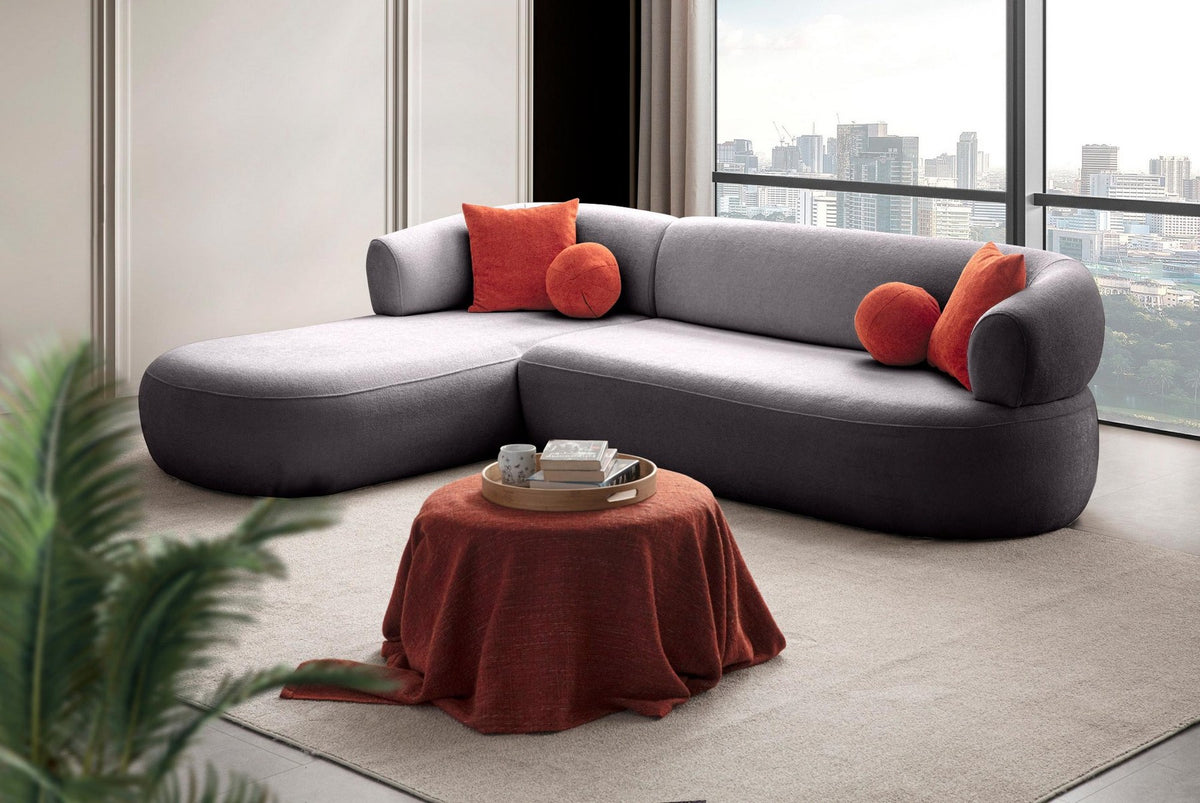 Dunkelgraues Ecksofa Roma von Hanah Home mit Boucle-Stoffbezug, Kunststoffbeinen und vier losen Kissen, links ausgerichtet.