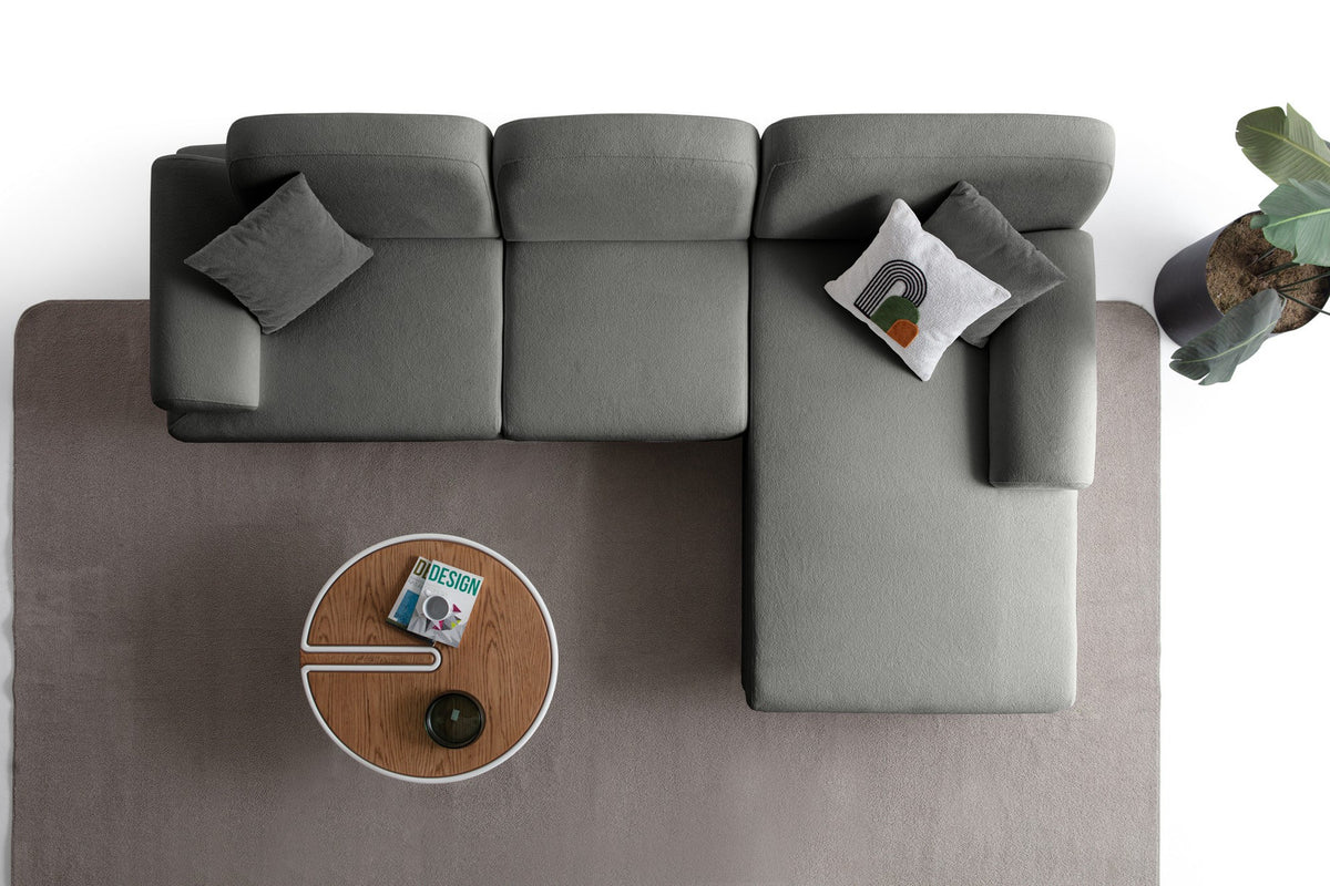 Anthrazitfarbenes Eck-Schlafsofa Aries von Hanah Home mit Coco-Boucle-Bezug, Holzbeinen und ausklappbarer Liegefläche in Wohnraumumgebung.
