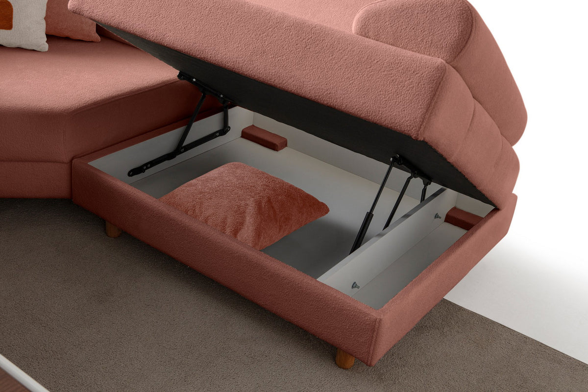 Modulares Eck-Schlafsofa in Altrosa mit Boucle-Stoffbezug, Holzbeinen und vier Kissen, fotografiert aus frontaler Perspektive.