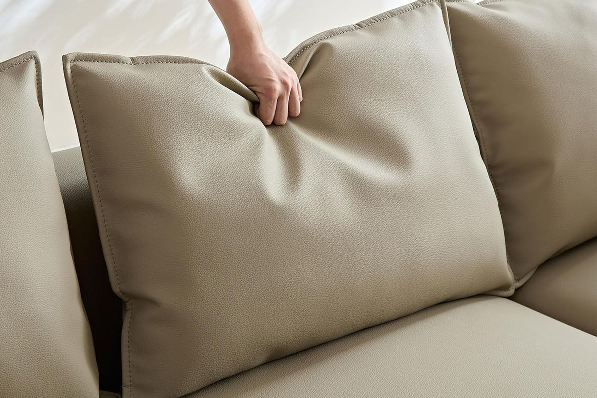 Braunes Ecksofa Venedik mit glattem Kunstlederbezug, rechter Ausrichtung, sieben Kissen und Kunststoffbeinen auf hellem Hintergrund.